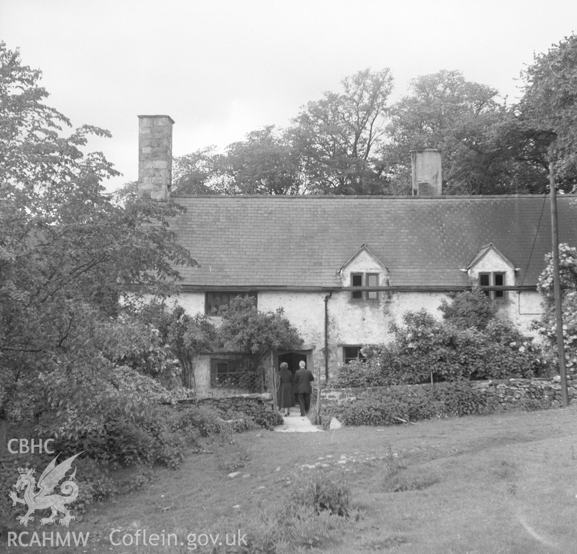 Black and white nitrate negative showing exterior view, with two figures, of Brithdir Mawr, Flintshire.