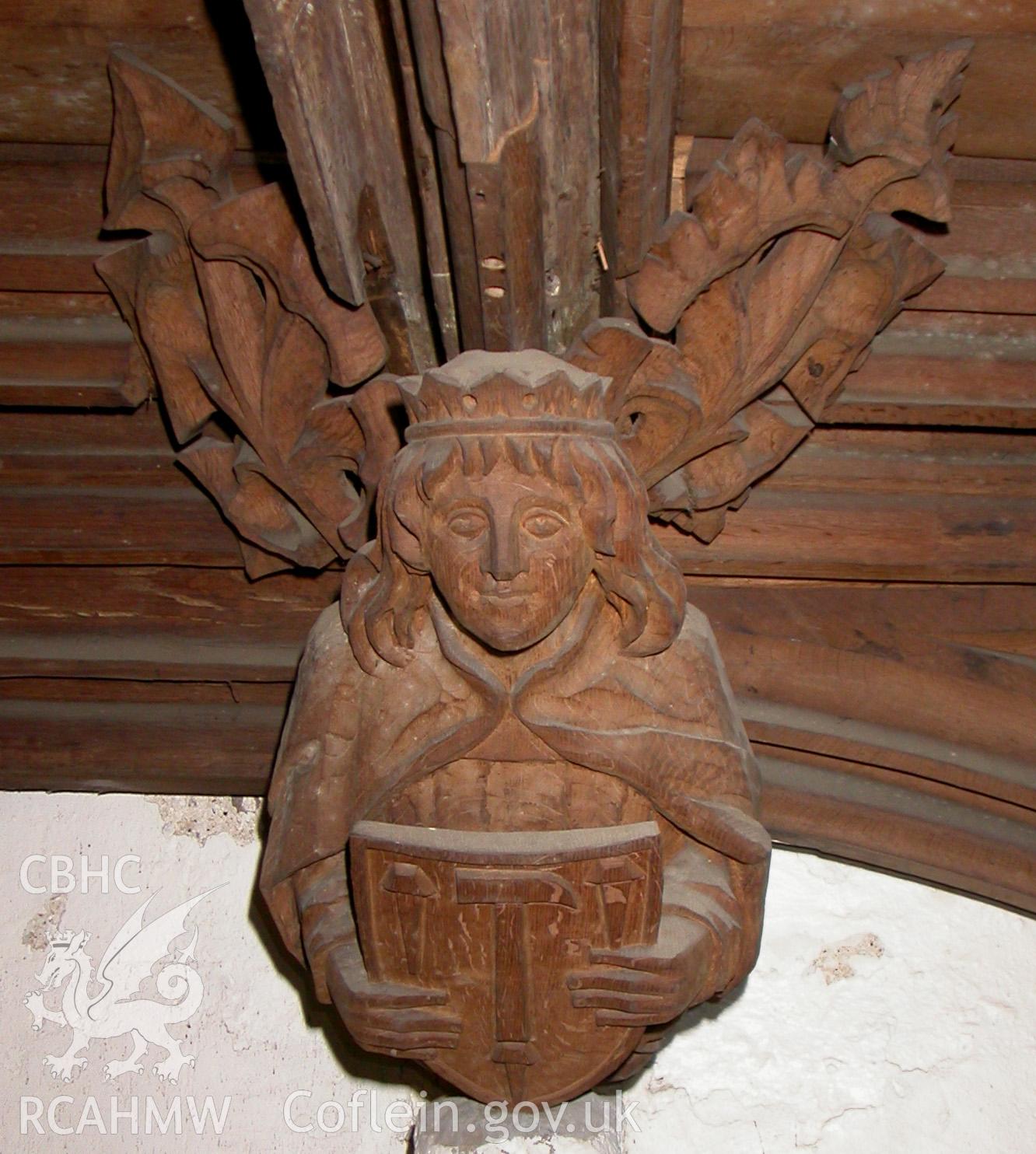 Carved wooden head at east end, to south.
