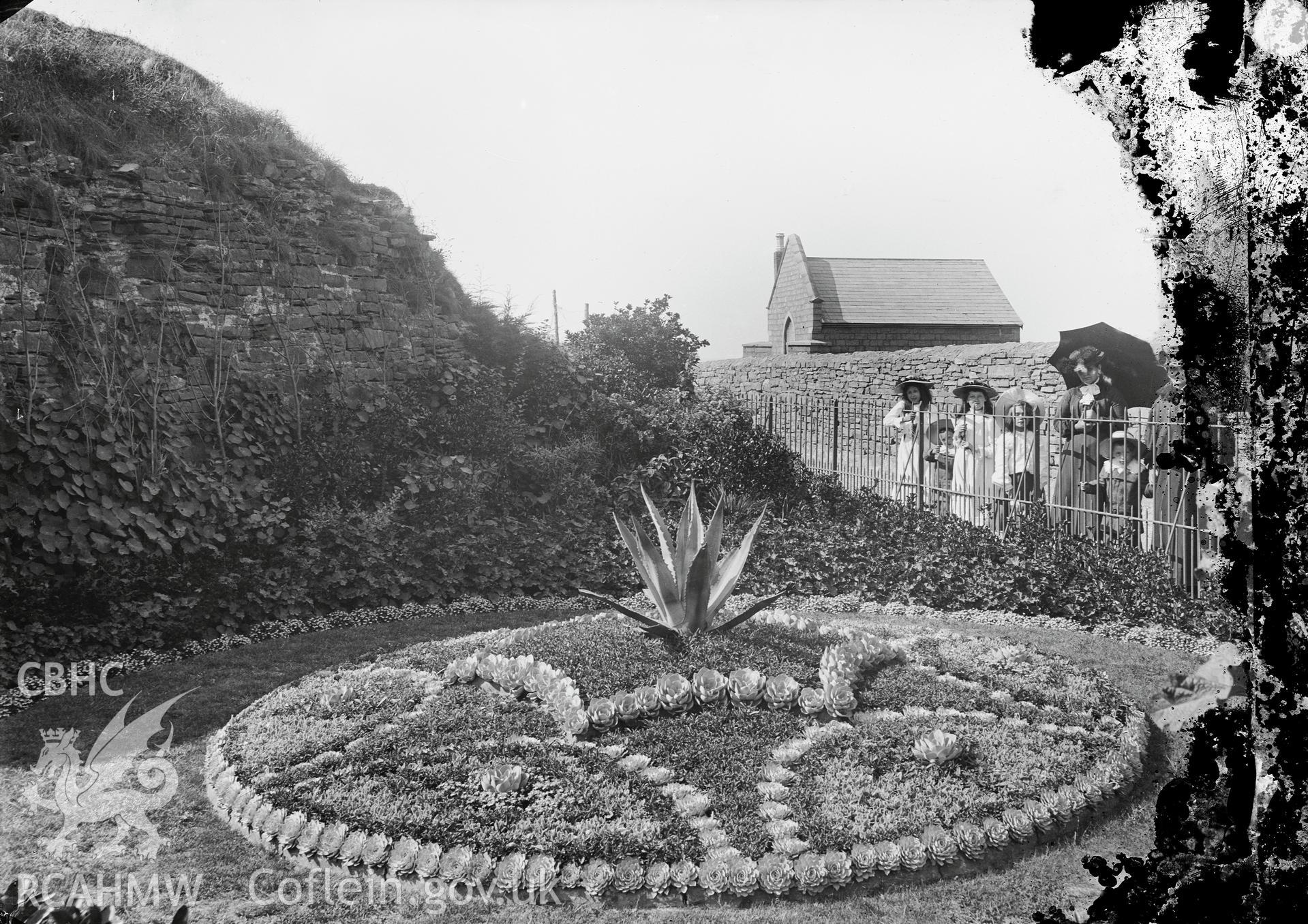 Black and white image dating from c.1910 showing flower beds at Aberystwyth Castle grounds,  taken by Emile T. Evans.