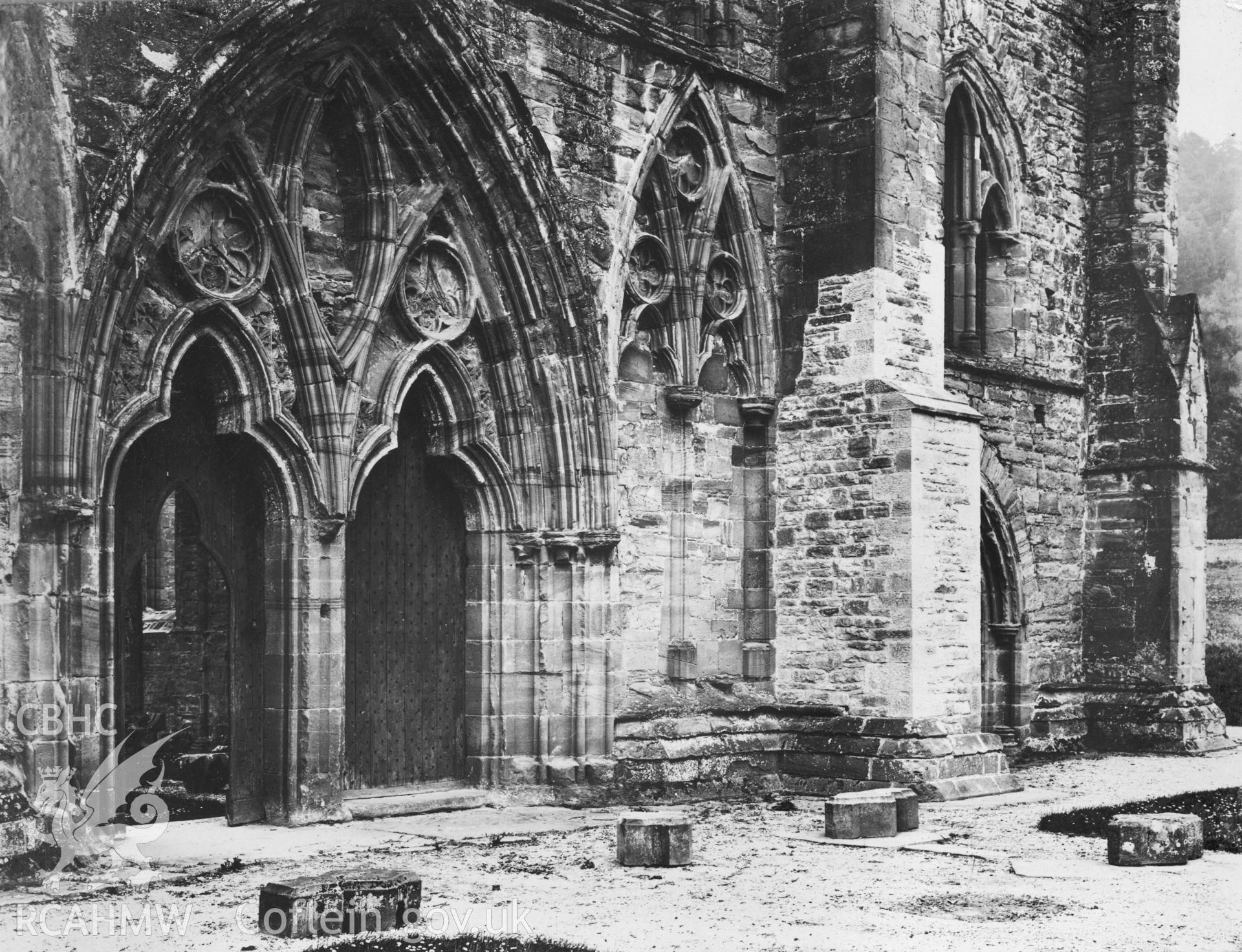 Black and white photo showing view of west facade of Tintern Abbey showing modern restoration to buttress taken circa 1905.