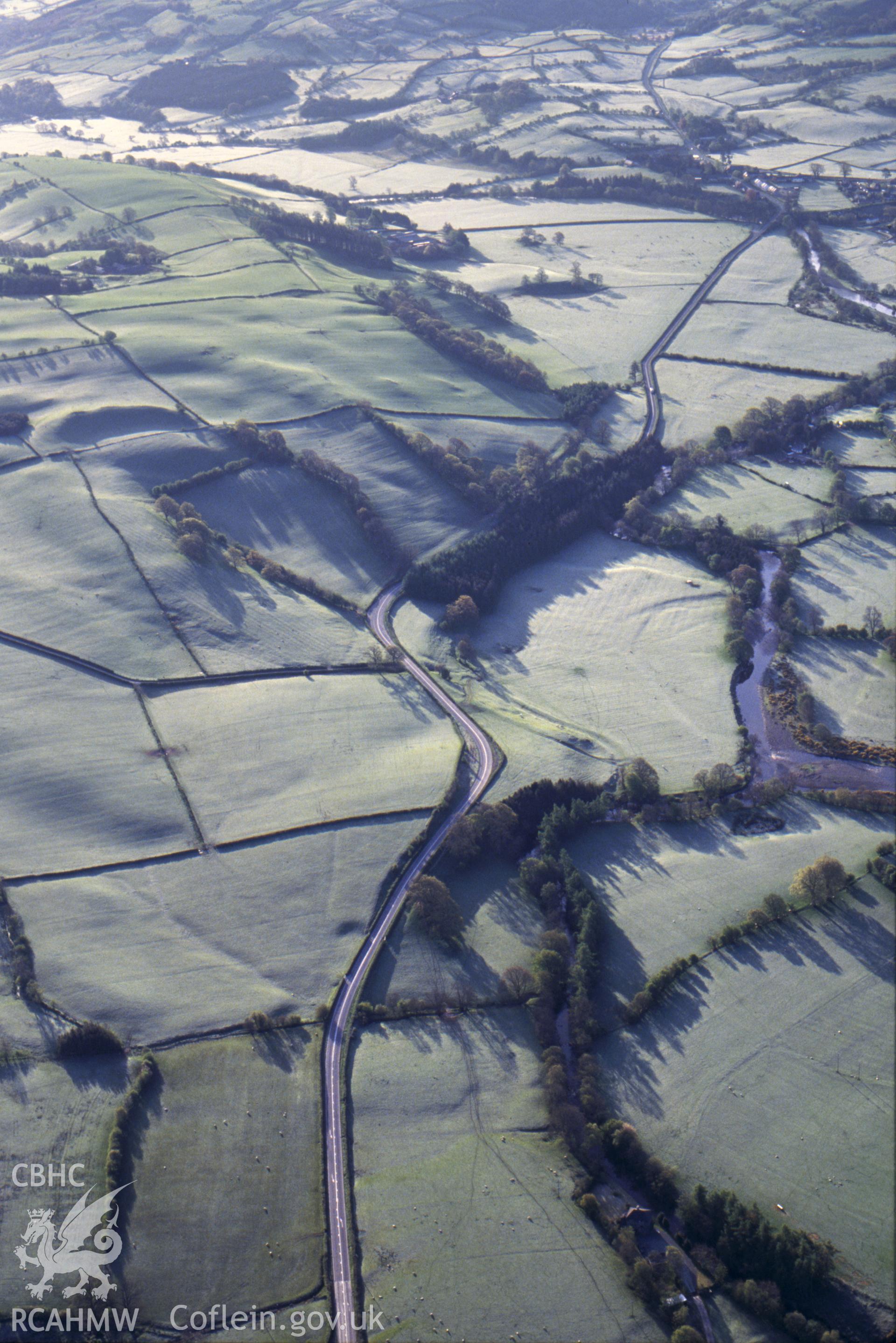 Slide of RCAHMW colour oblique aerial photograph of the area around Coed Bach to the south-east of Llangadfan, taken by C.R. Musson, 1993.