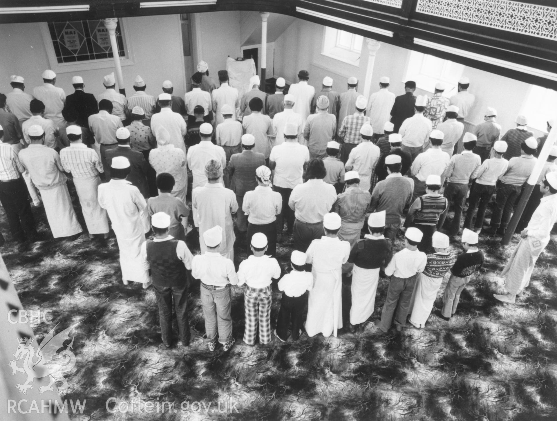 1 b/w print showing interior of Severn Road Mosque, Cardiff, with men and boys at prayer; collated by the former Central Office of Information.