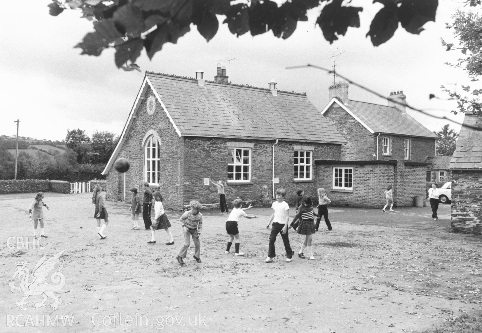 1 b/w print showing exterior view of the primary school, Llangybi (Monmouthshire) with children playing; collated by the former Central Office of Information.