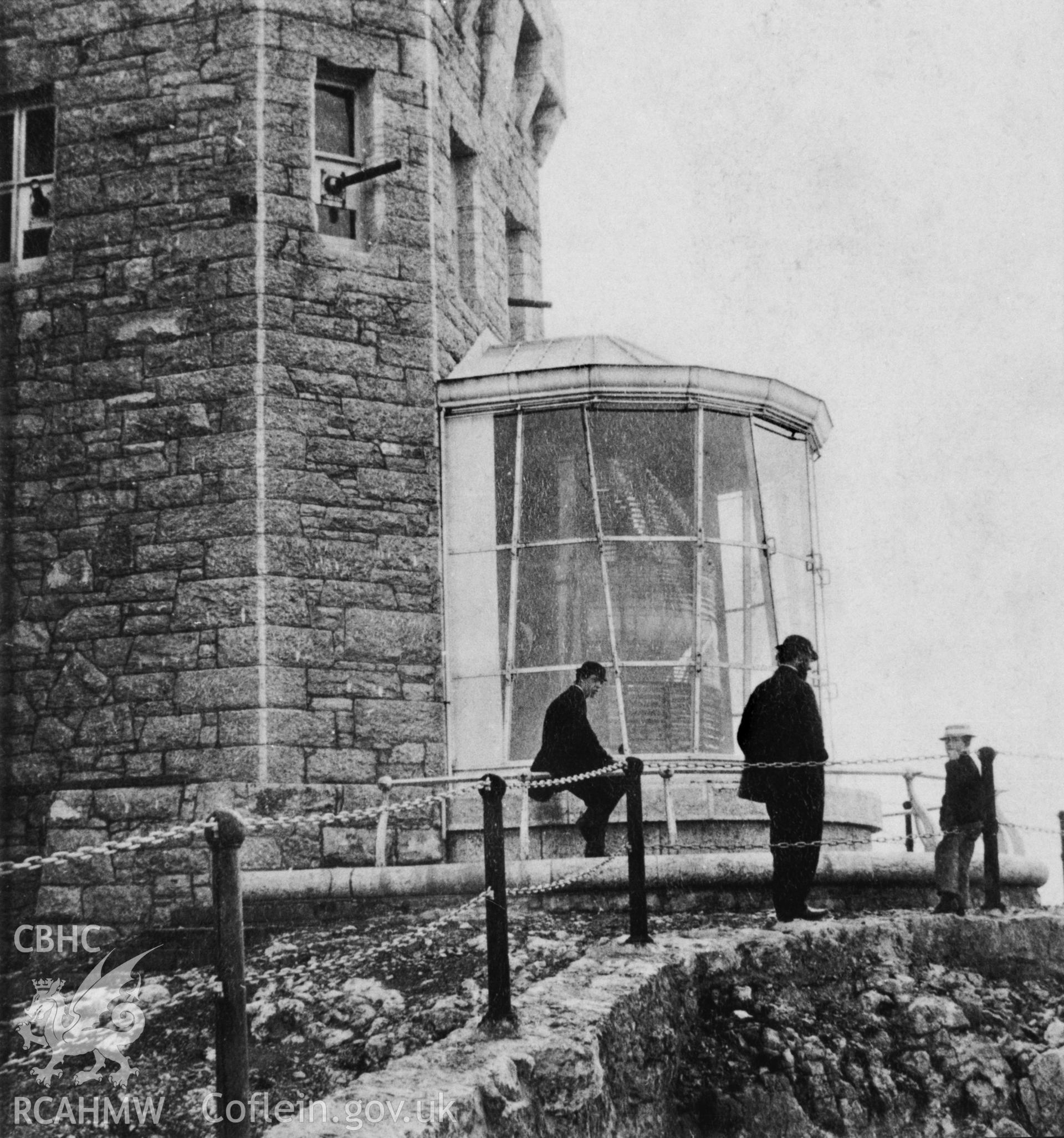 Exterior view of lighthouse with two men and a boy in the foreground