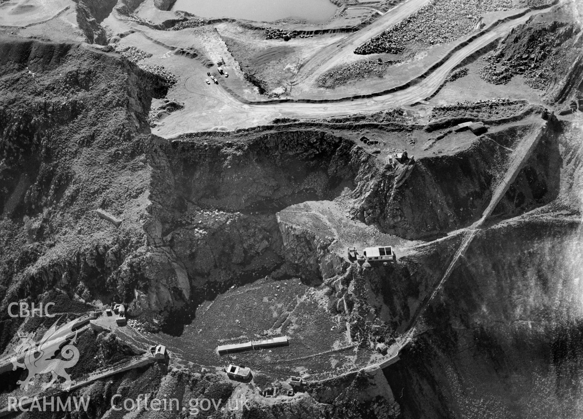 RCAHMW Black and white oblique aerial photograph of Penmaenmawr Stone Quarry, Penmaenmawr, taken on 18/04/1998 by Toby Driver