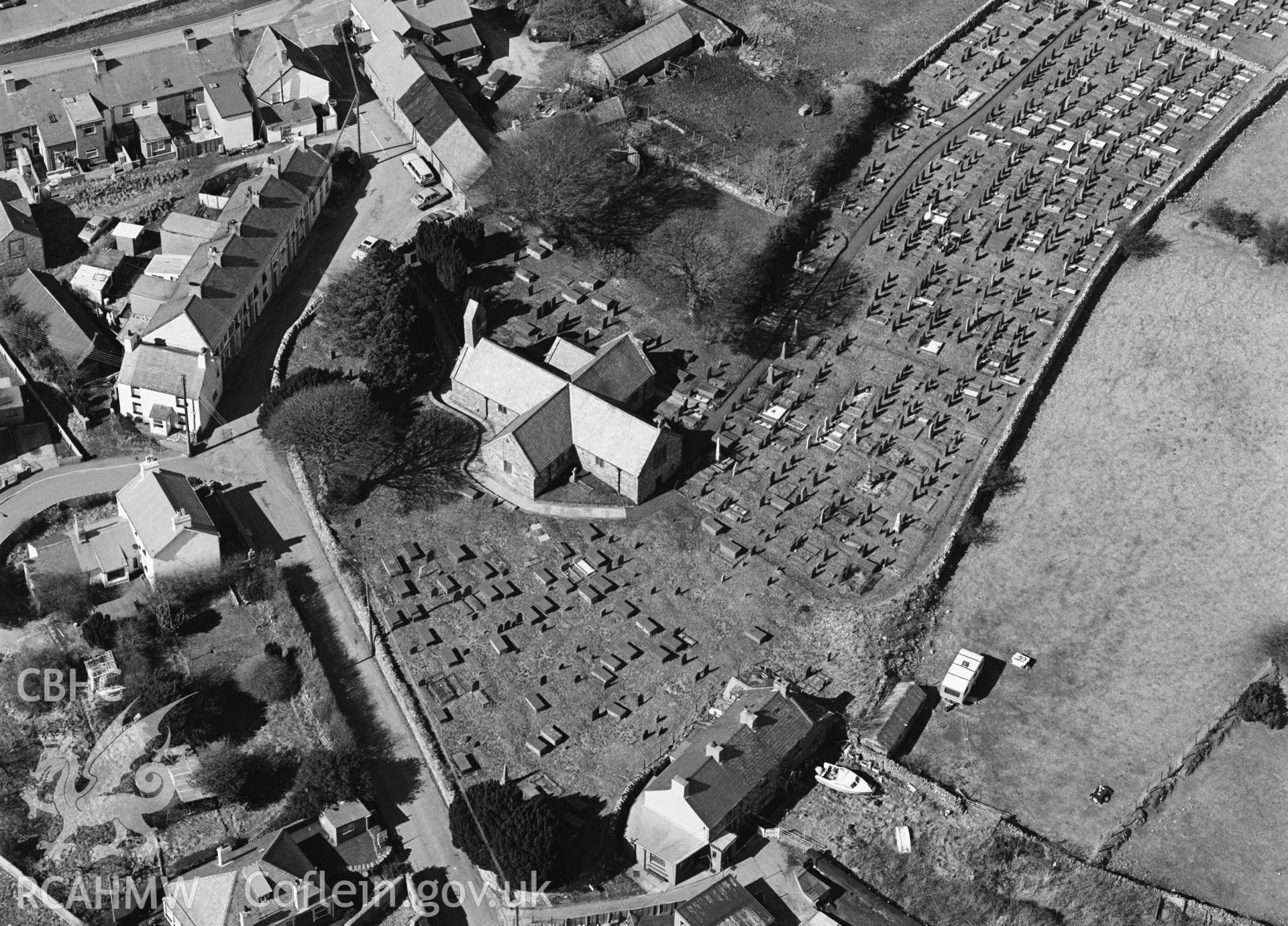 RCAHMW black and white oblique aerial photograph of St Aelhaerarns Church, taken by C R Musson, 29/03/1996.