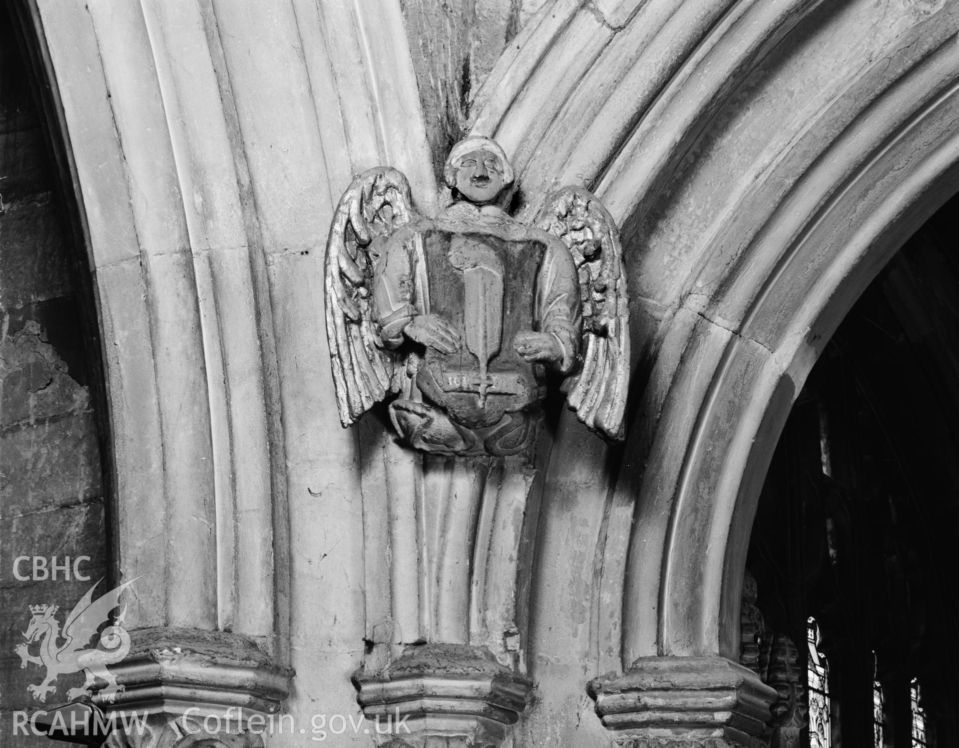Mold Parish Church; b&w photograph showing heraldic badge in nave arcade, taken by Iain Wright, October 2001.