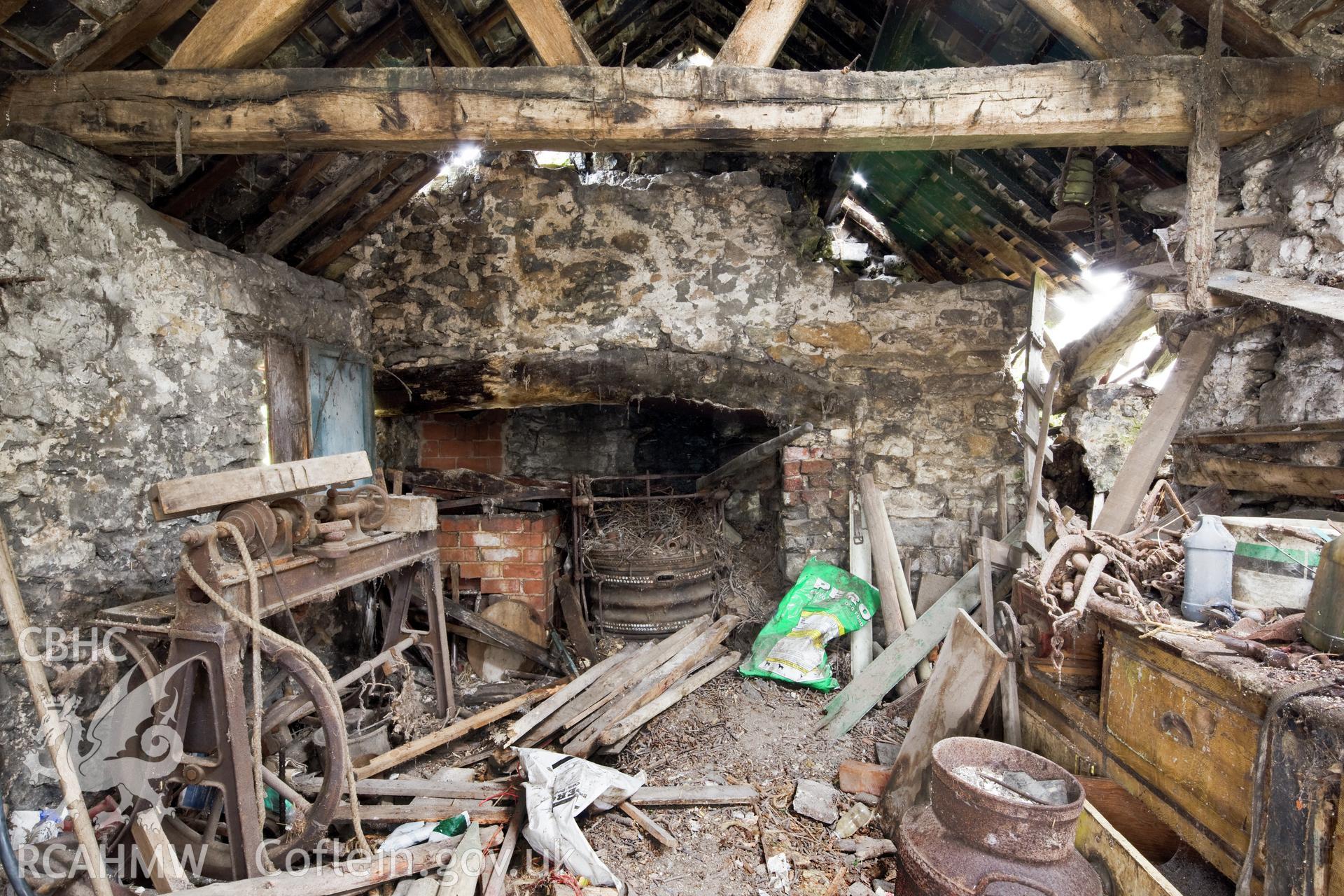 Interior of workshop, treadle lathe, blacksmiths bellows, workbench.