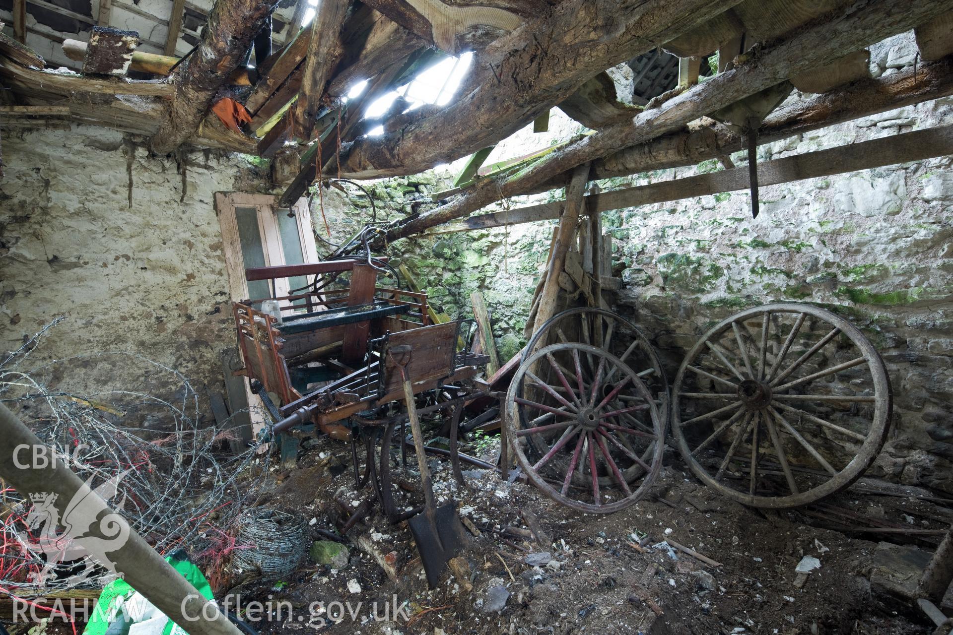 Interior with open carriage and cart wheels.