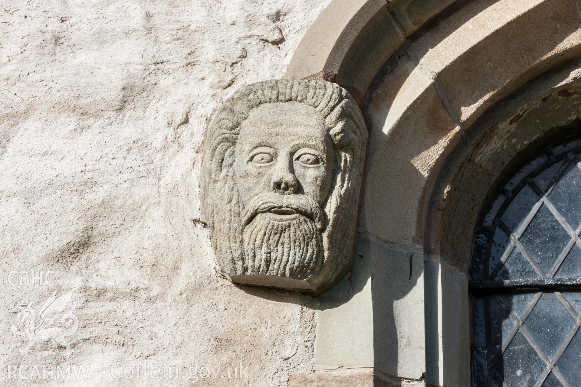 Carved stone head on window arch, south wall