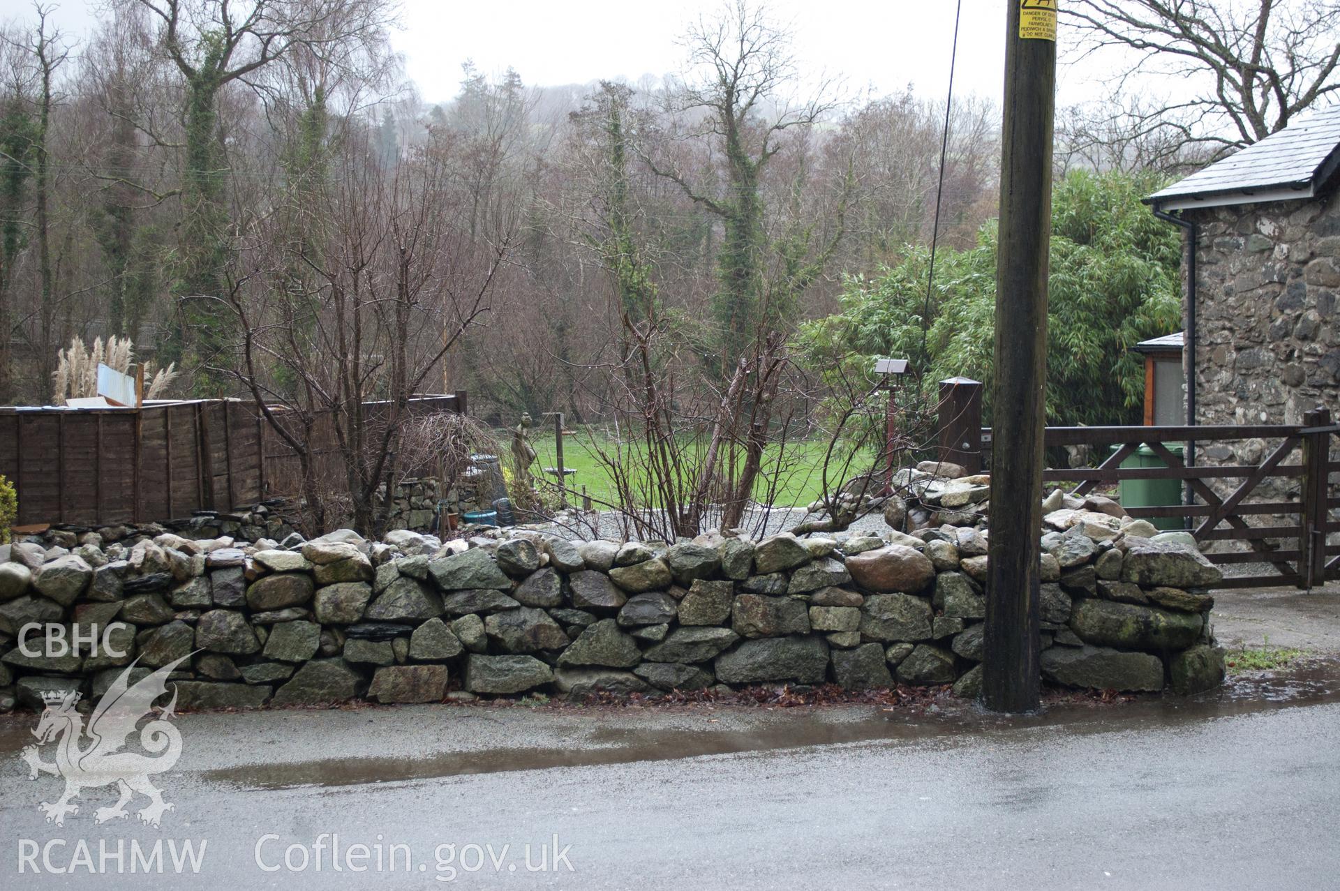 Marian Mawr archaeological assessment; Section B-C, view from SSW showing view between properties on street where water main meets the road, taken by Robert Evans of Gwynedd Archaeological Trust, 5th February 2016.