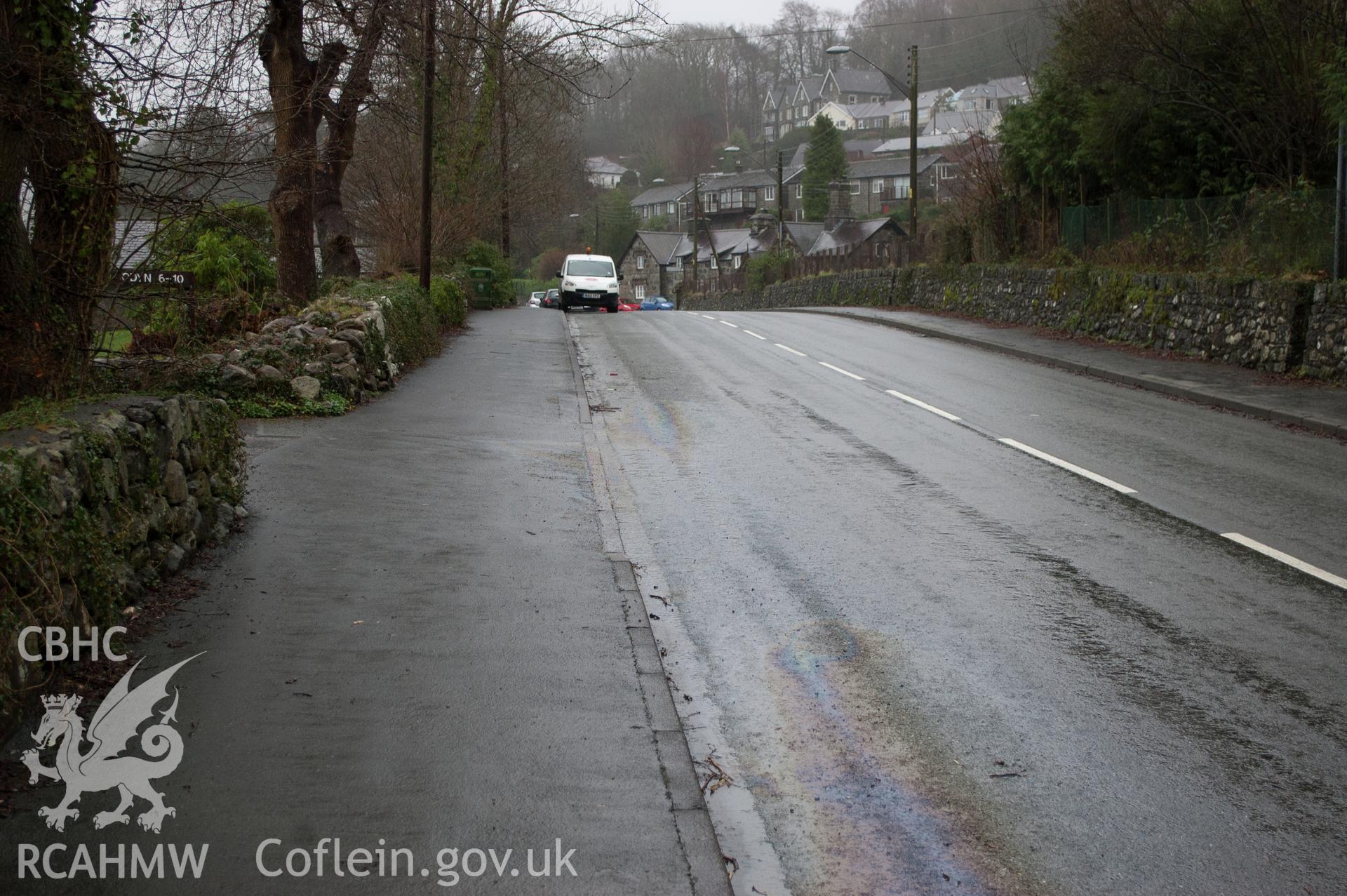 Marian Mawr archaeological assessment; section C-D, view from W showing view along street showing pipe route in pavement, taken by Robert Evans of Gwynedd Archaeological Trust, 5th February 2016.