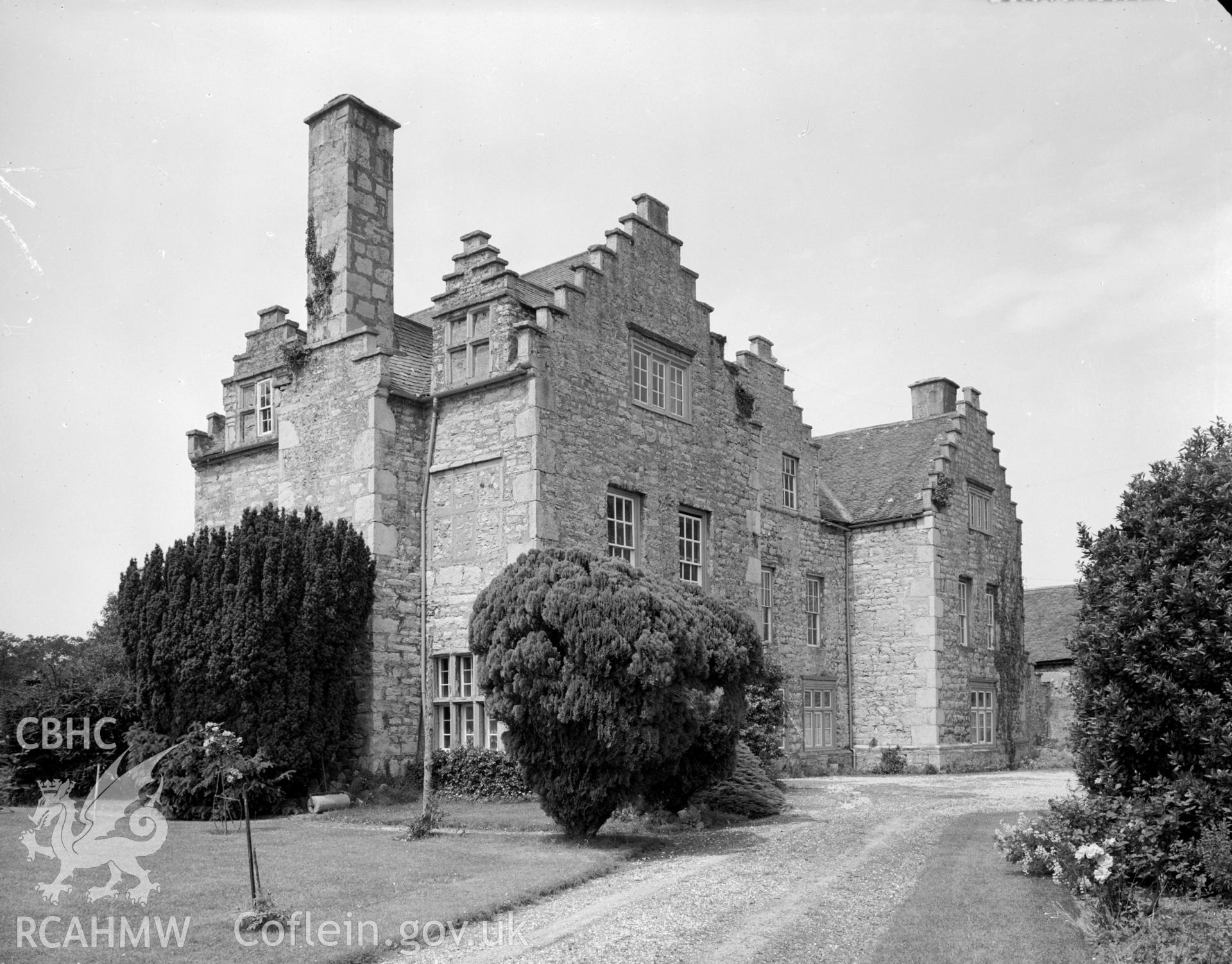 View of a former mansion now farmhouse showing the stepped gables, garden and driveway.