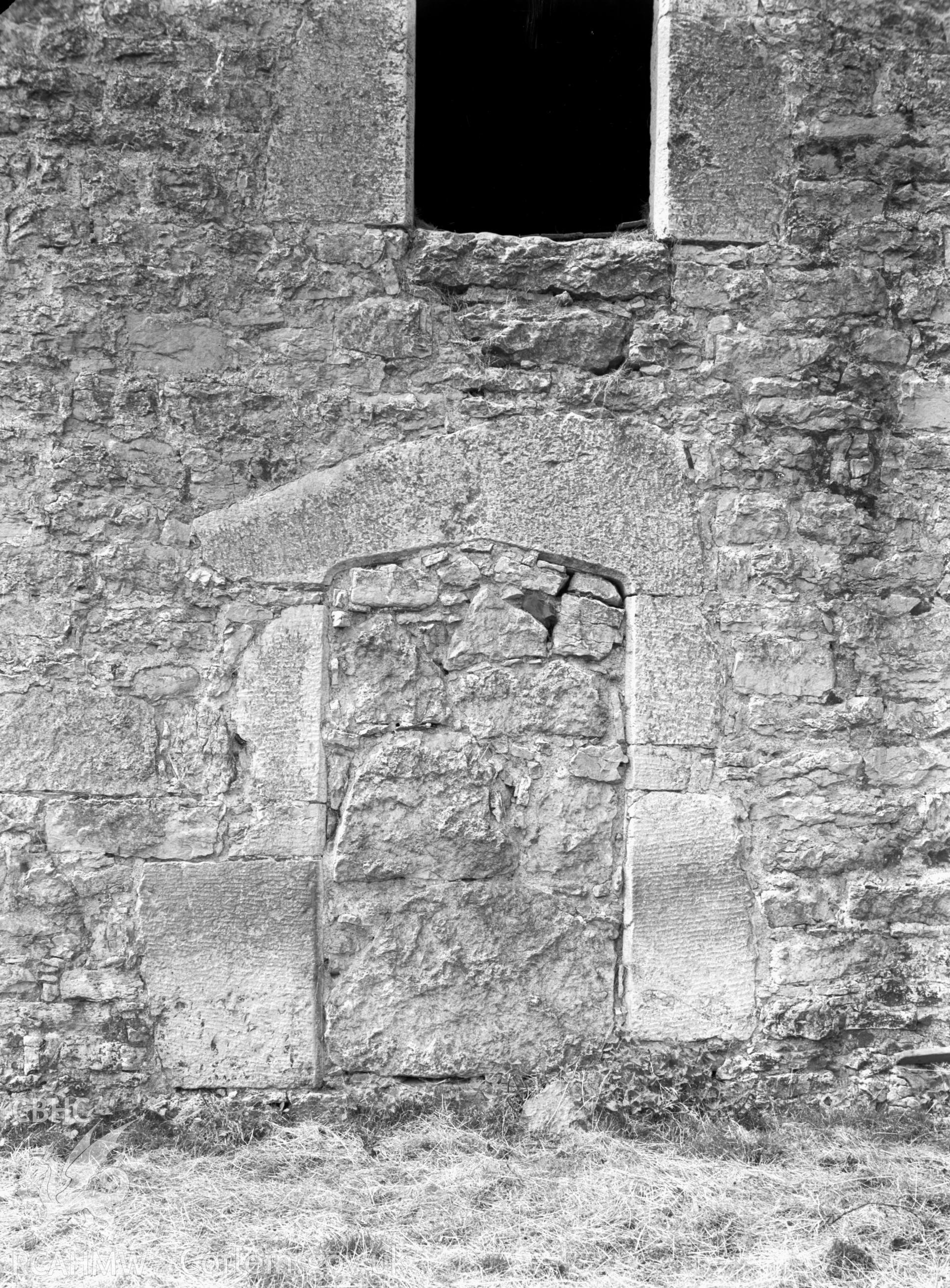 A view of an outline of a doorway, it has been blocked with stone.