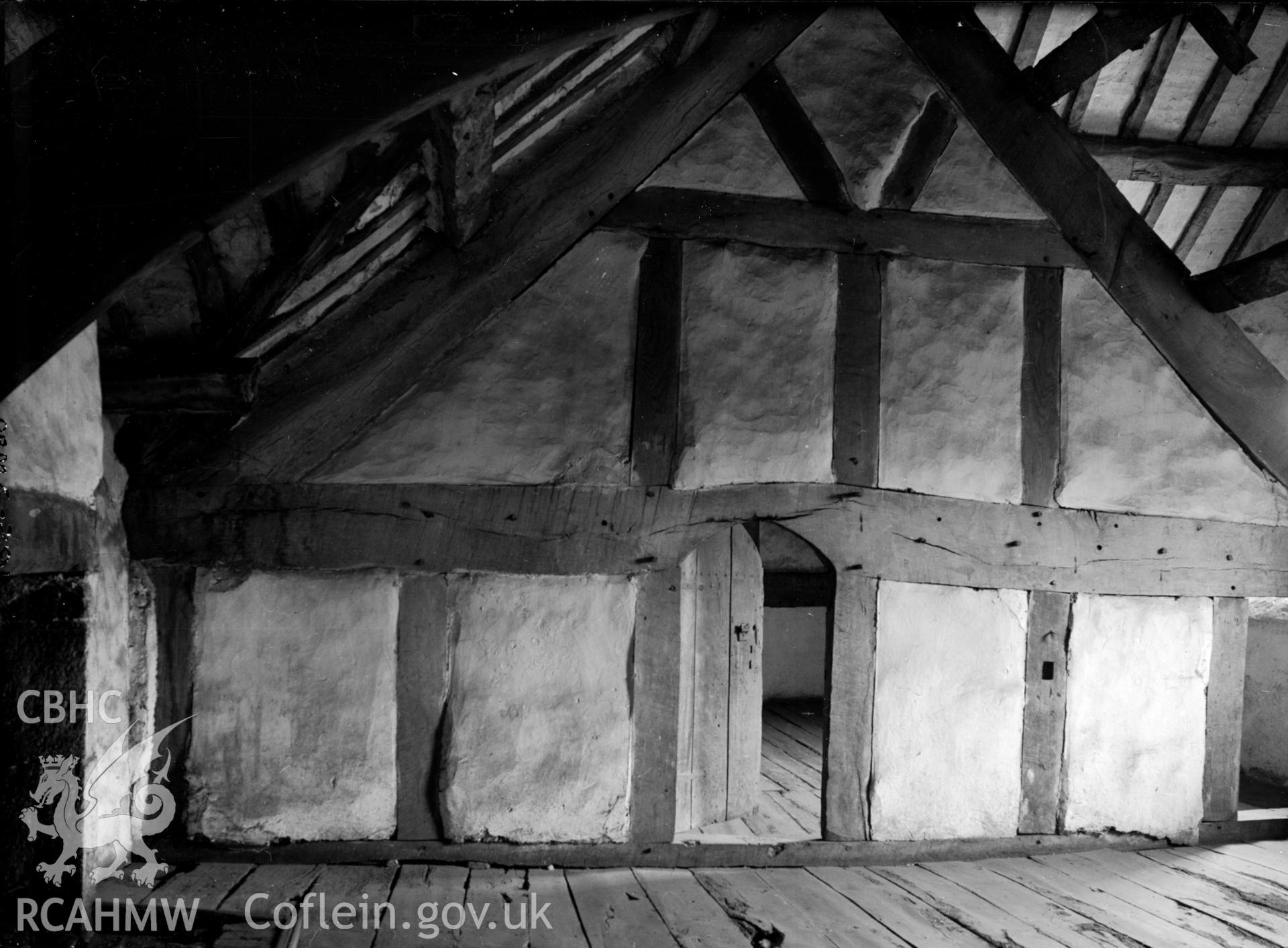 A view of timber beamed roof and a timber framed wall..