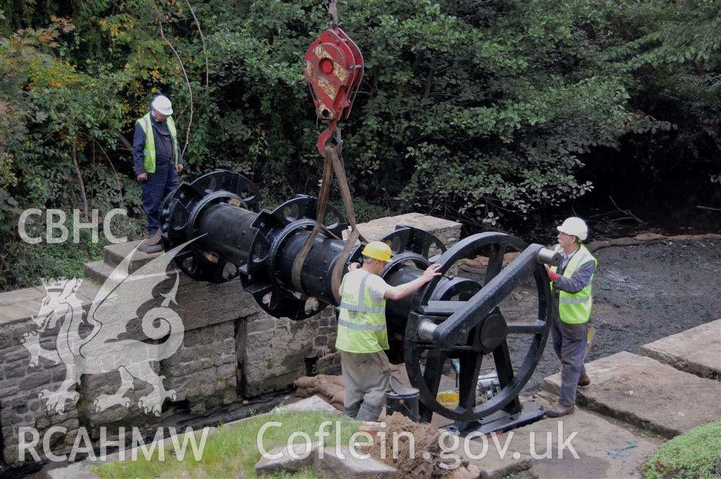 Digital image relating to Melingriffith Water Pump: Wheel axle, hubs, and crank arms being lowered onto bearing pedestals.