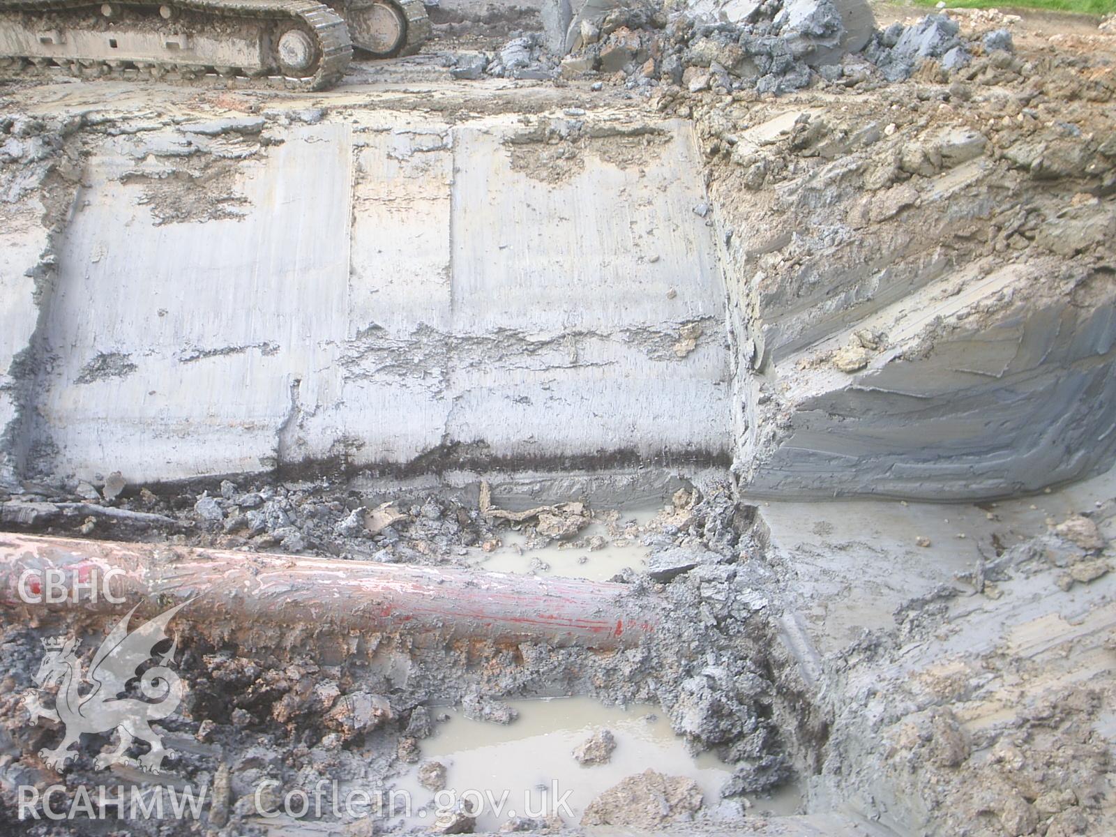 Colour digital photograph showing a tie-in trench, from the South.
