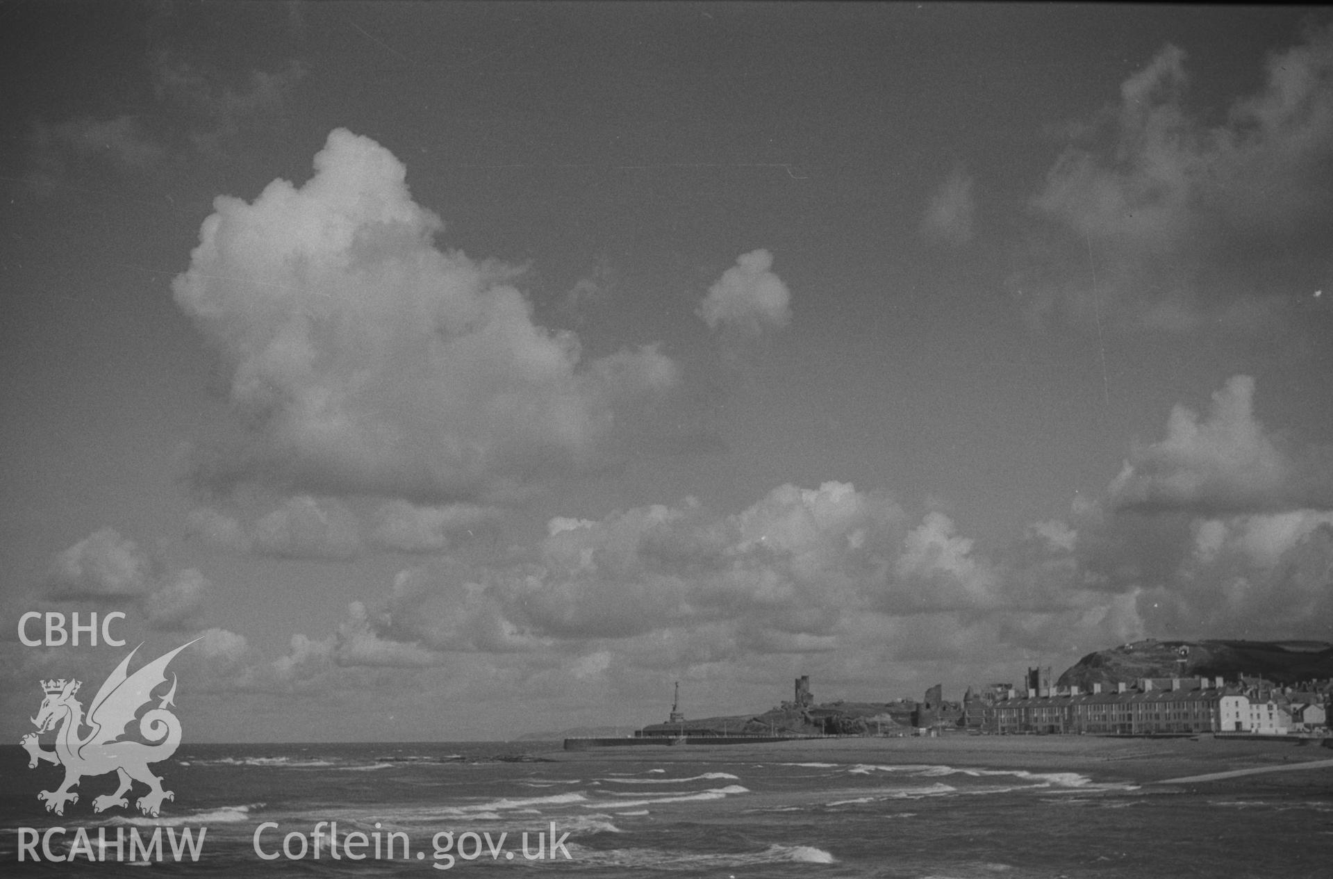 Digital copy of a black and white negative showing Aberystwyth from Tanybwlch pier, including view of war memorial, castle and south marine terrace. Photographed by Arthur O. Chater in September 1964 from Grid Reference SN 5787 8076, looking north.