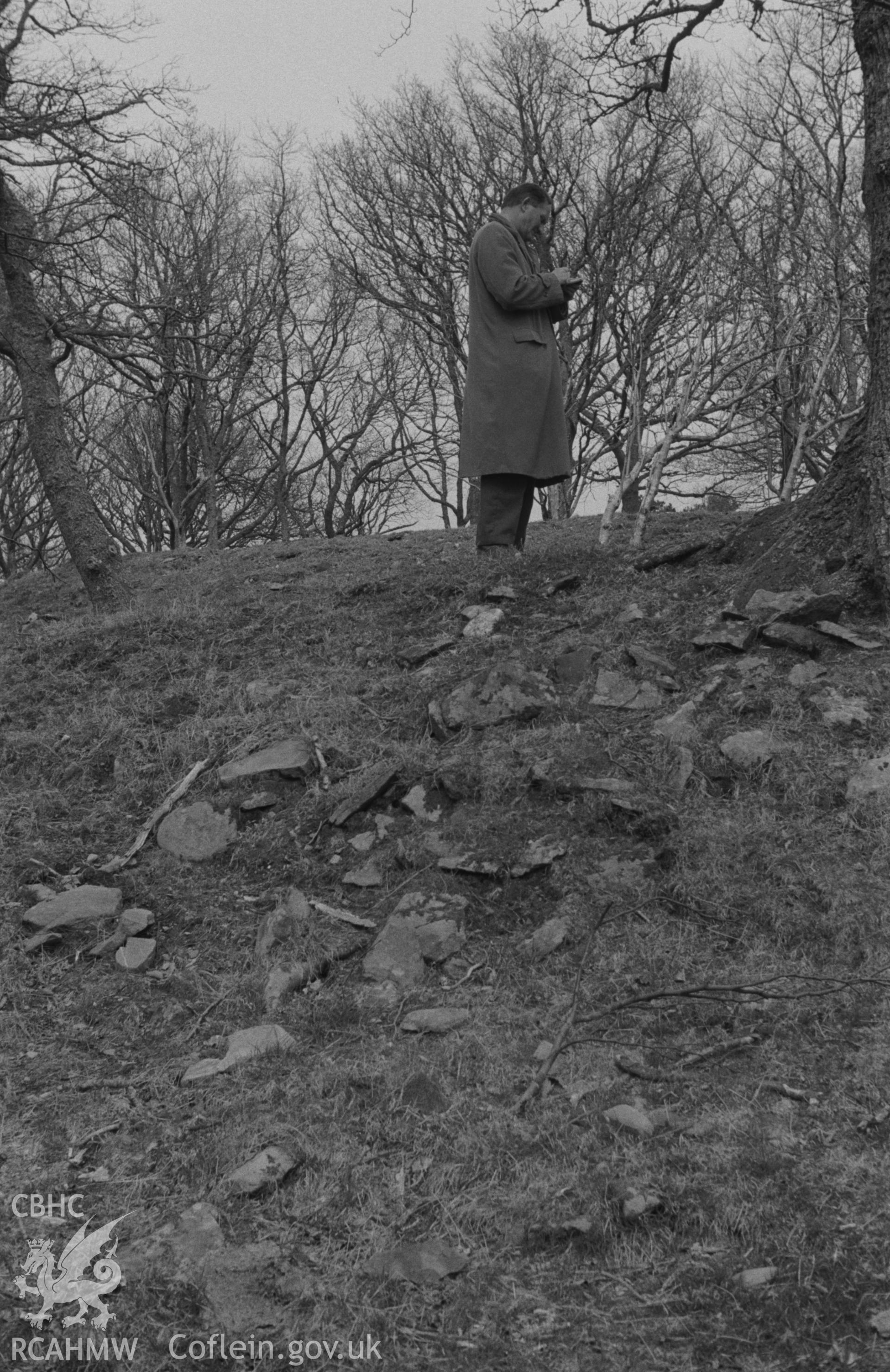 Digital copy of a black and white negative showing figure at Craig Gwytheyrn hillfort. Photographed by Arthur O. Chater in April 1967.