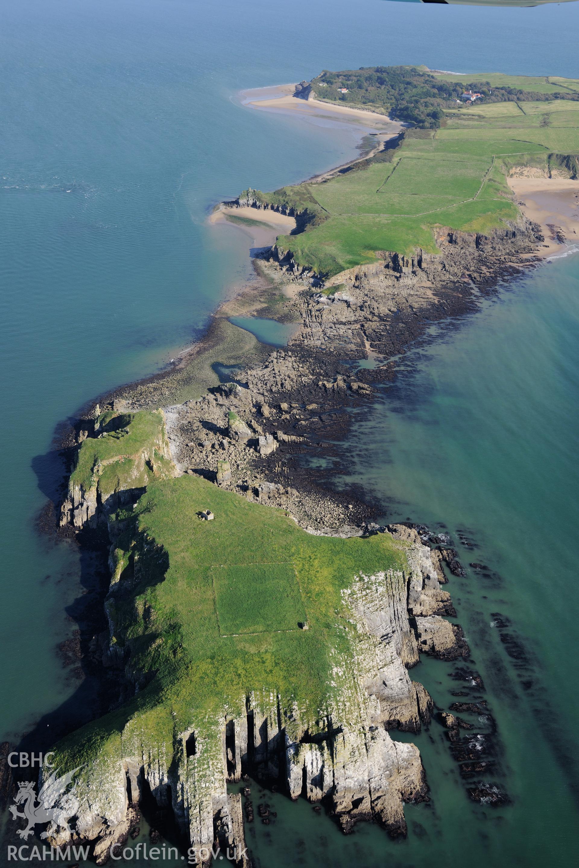 Monastic buildings, chapel ruins & field enclosure on St. Margaret's Island, with Caldey Island beyond & small sound in between. Oblique aerial photograph taken during RCAHMW's programme of archaeological aerial reconnaissance by Toby Driver, 30/09/2015.