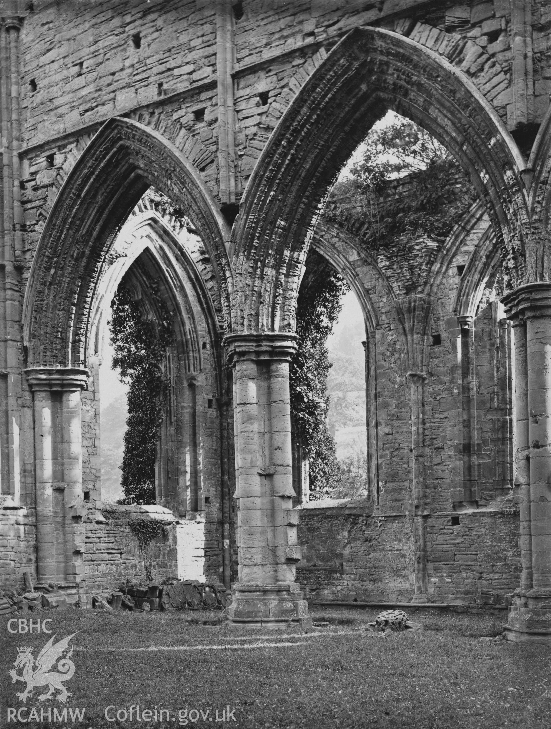 Digital copy of an early National Buildings Record photograph showing an interior view of the Presbytery arcade at Tintern Abbey looking southeast.