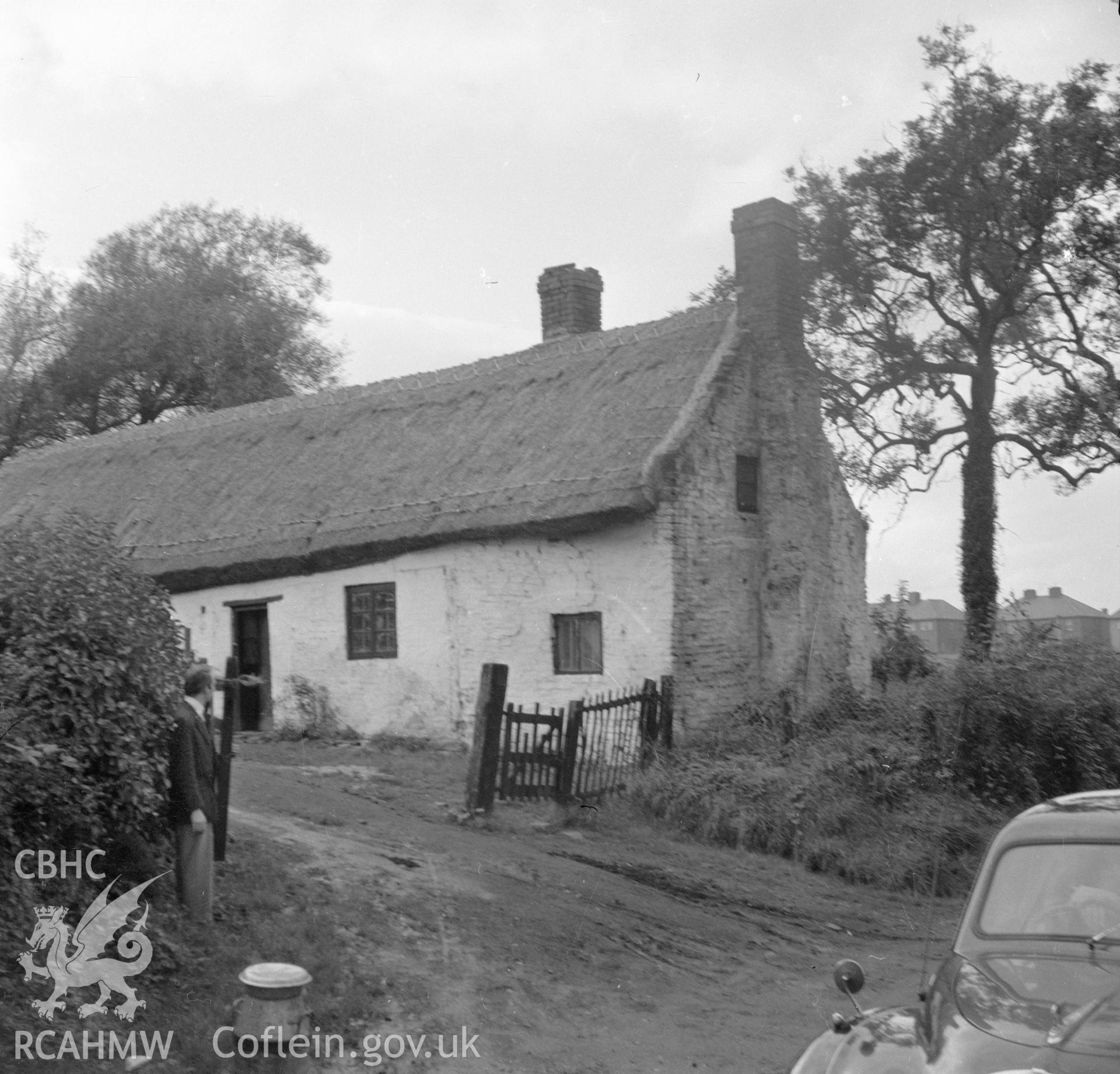 Digital copy of a nitrate negative showing an exterior view of a cruck house at Northop, Flintshire.