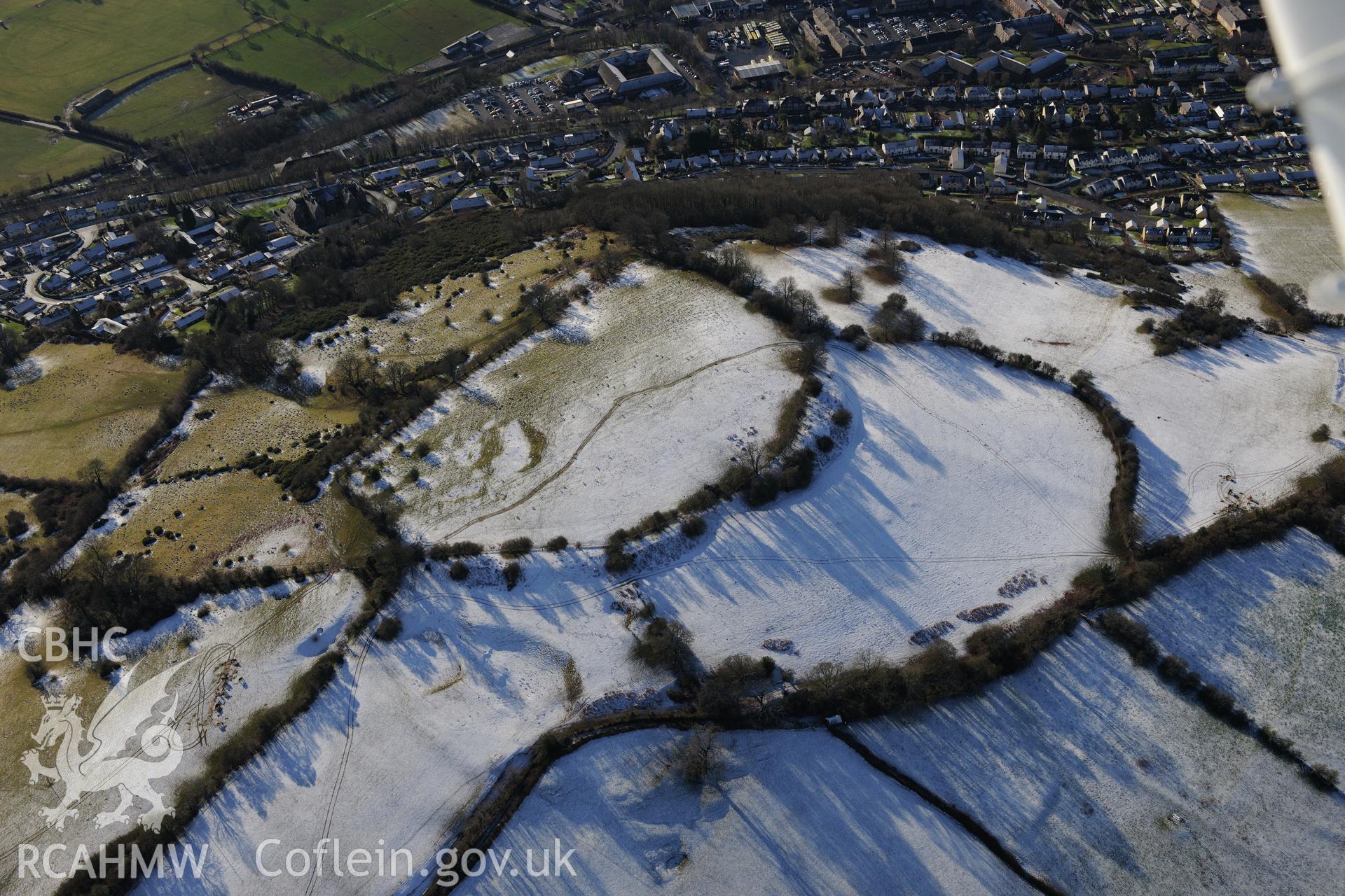 Slwch camp or Tump Hillfort and the site of St. Elenud's chapel and well, with housing in Brecon beyond. Oblique aerial photograph taken during the Royal Commission?s programme of archaeological aerial reconnaissance by Toby Driver on 15th January 2013.