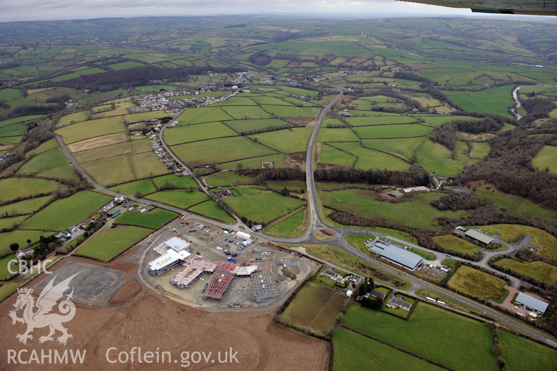 Ysgol Bro Teifi under construction, the A486 Llandysul bypass, and the town of Llandysul beyond. Oblique aerial photograph taken during the Royal Commission's programme of archaeological aerial reconnaissance by Toby Driver on 13th March 2015.