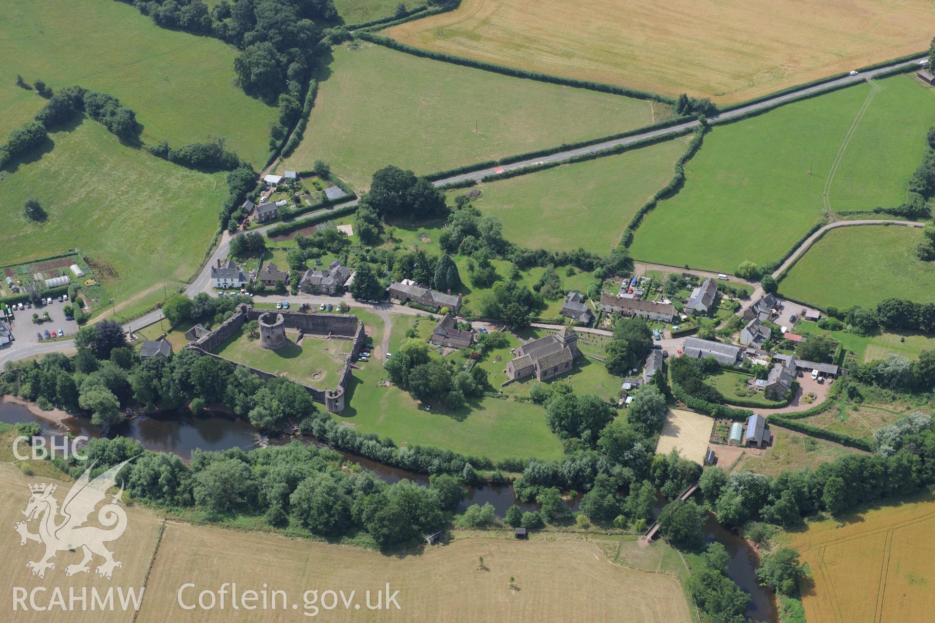 Skenfrith Castle, with St. Bridget's Church to north west & river Mynwy to north east, Skenfrith, Monmouth. Oblique aerial photograph taken during Royal Commission?s programme of archaeological aerial reconnaissance by Toby Driver on 1st August 2013.