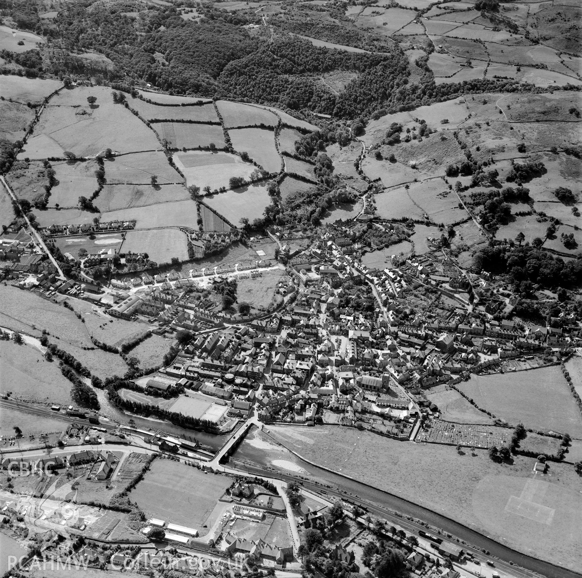Black and white oblique aerial photograph showing Dolgellau,View of the town looking south-east; the post-war housing boom is represented by houses under construction in Ffordd y Felin (centre left) and Ardd Fawr (bottom left). From Aerofilms album Merionethshire and Montgomeryshire, taken by Aerofilms Ltd and dated 1950.