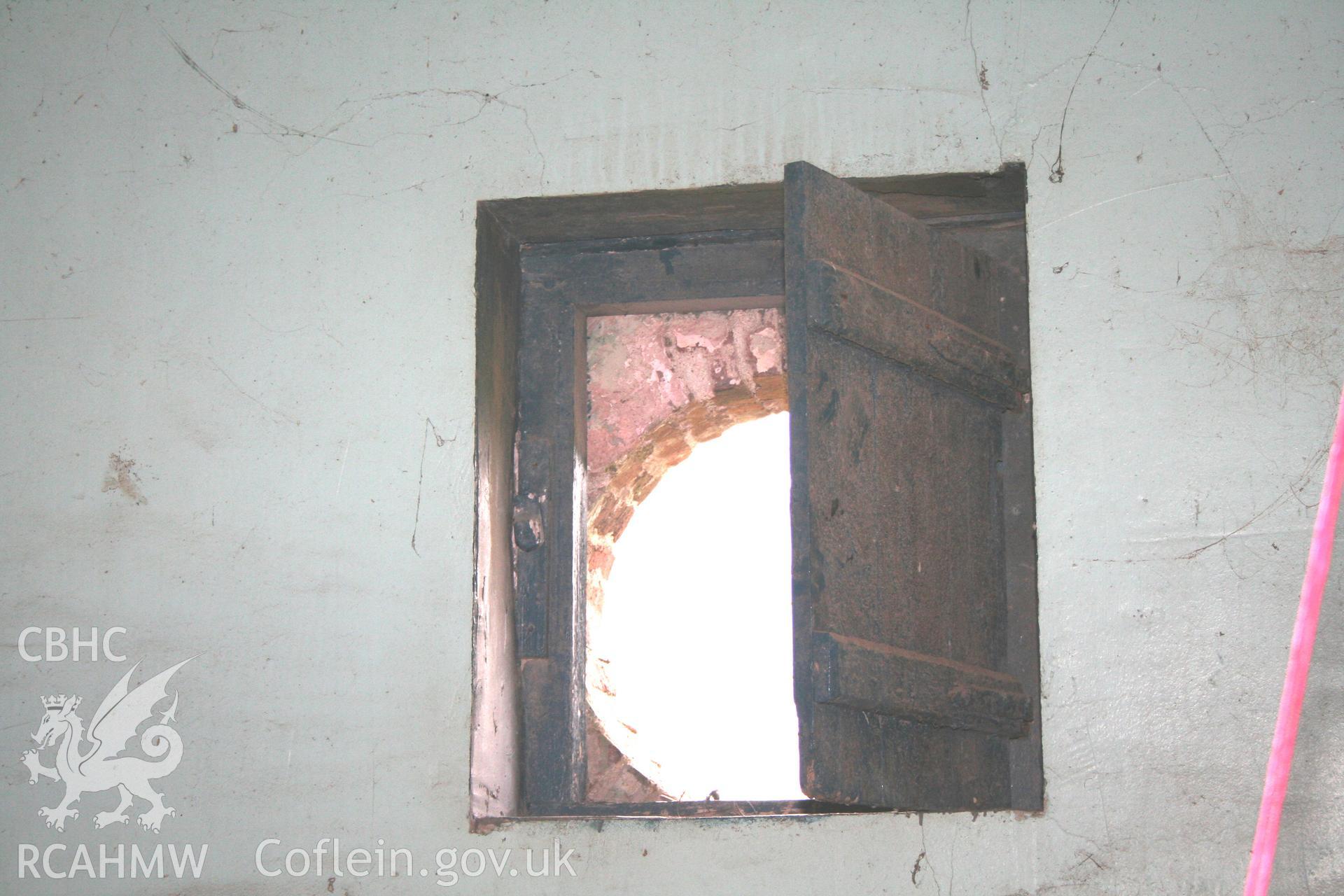 Interior view of engineering brick circular window with wooden shutter. Photographic survey of the southern range of cowhouses at Tan-y-Graig Farm, Llanfarian. Conducted by Geoff Ward and John Wiles, 11th December 2006.