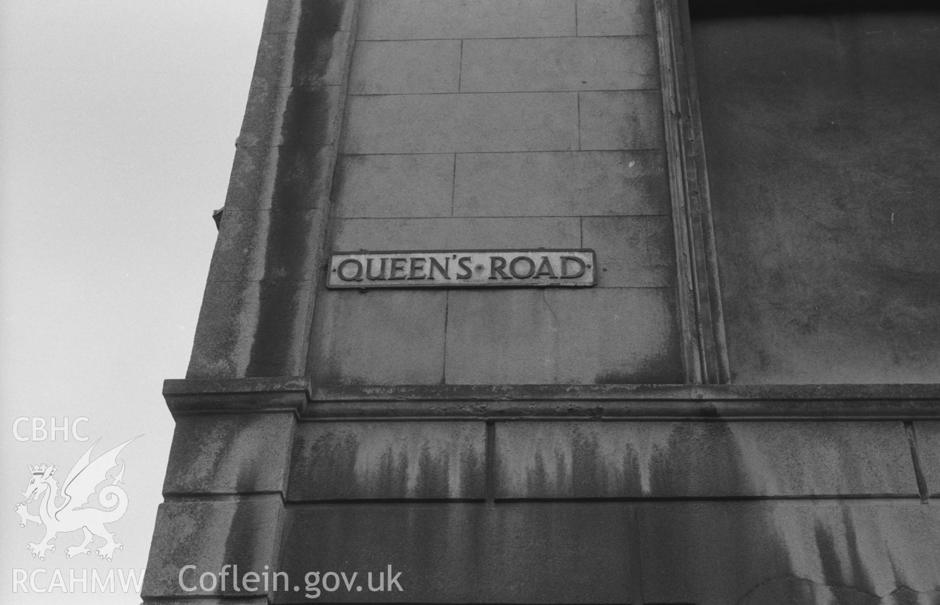 Digital copy of a black and white negative showing street name plaque on Queen's Road, Aberystwyth. Photographed by Arthur O. Chater in September 1966.