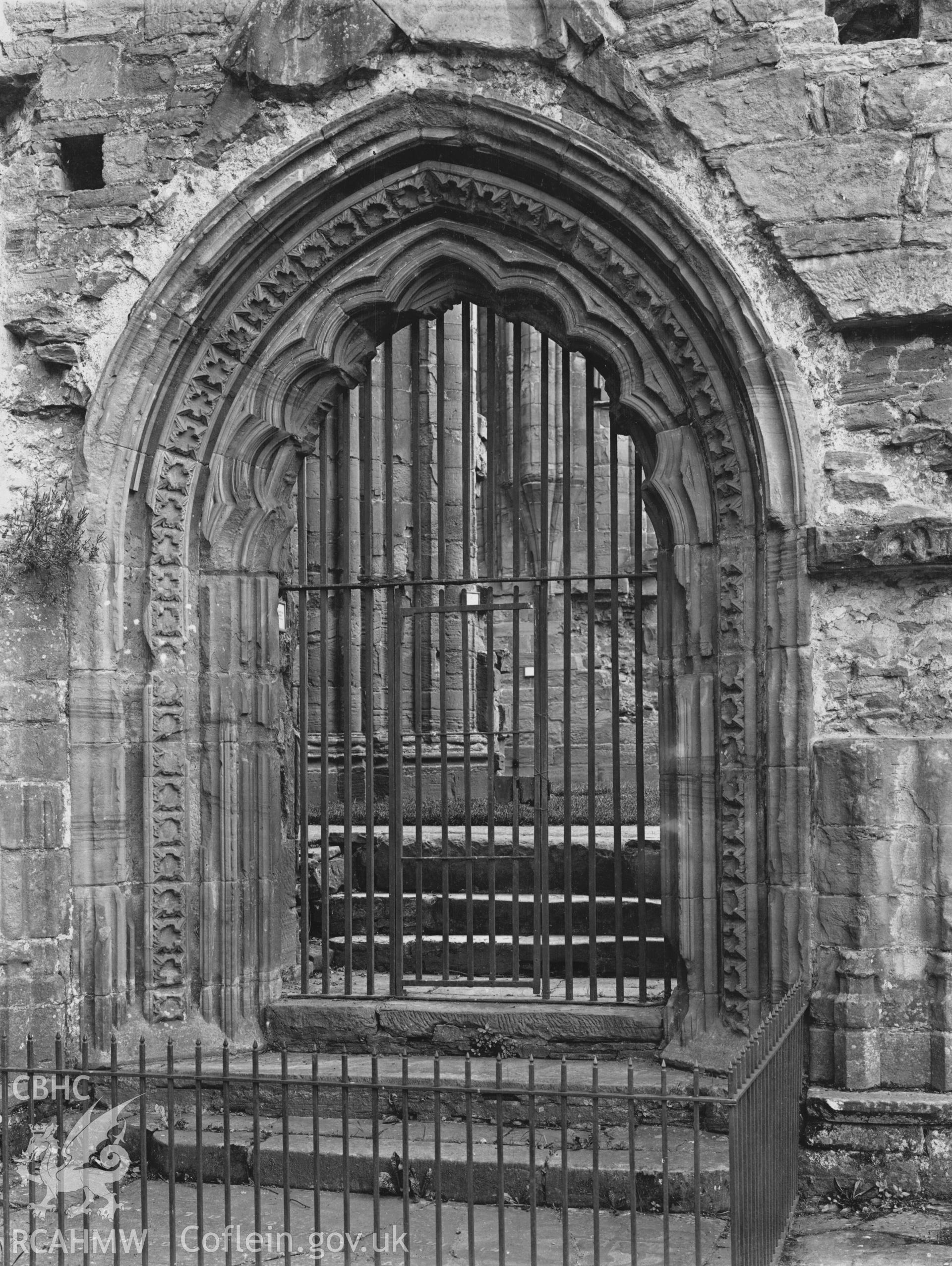 Digital copy of an early National Buildings Record photograph showing doorway from the cloister to the choir at Tintern Abbey.