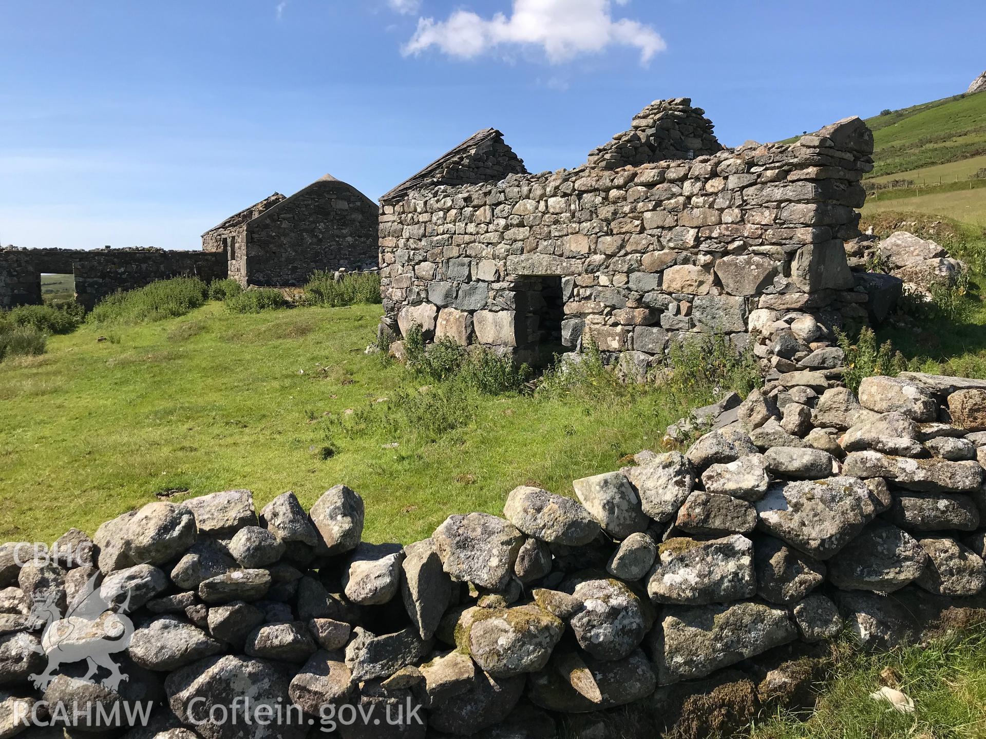 Colour photo showing view of drystone walls and remnants of possible outbuildings at Cae-Mwynen house, Clynnog, taken by Paul R. Davis, 24th June 2018.