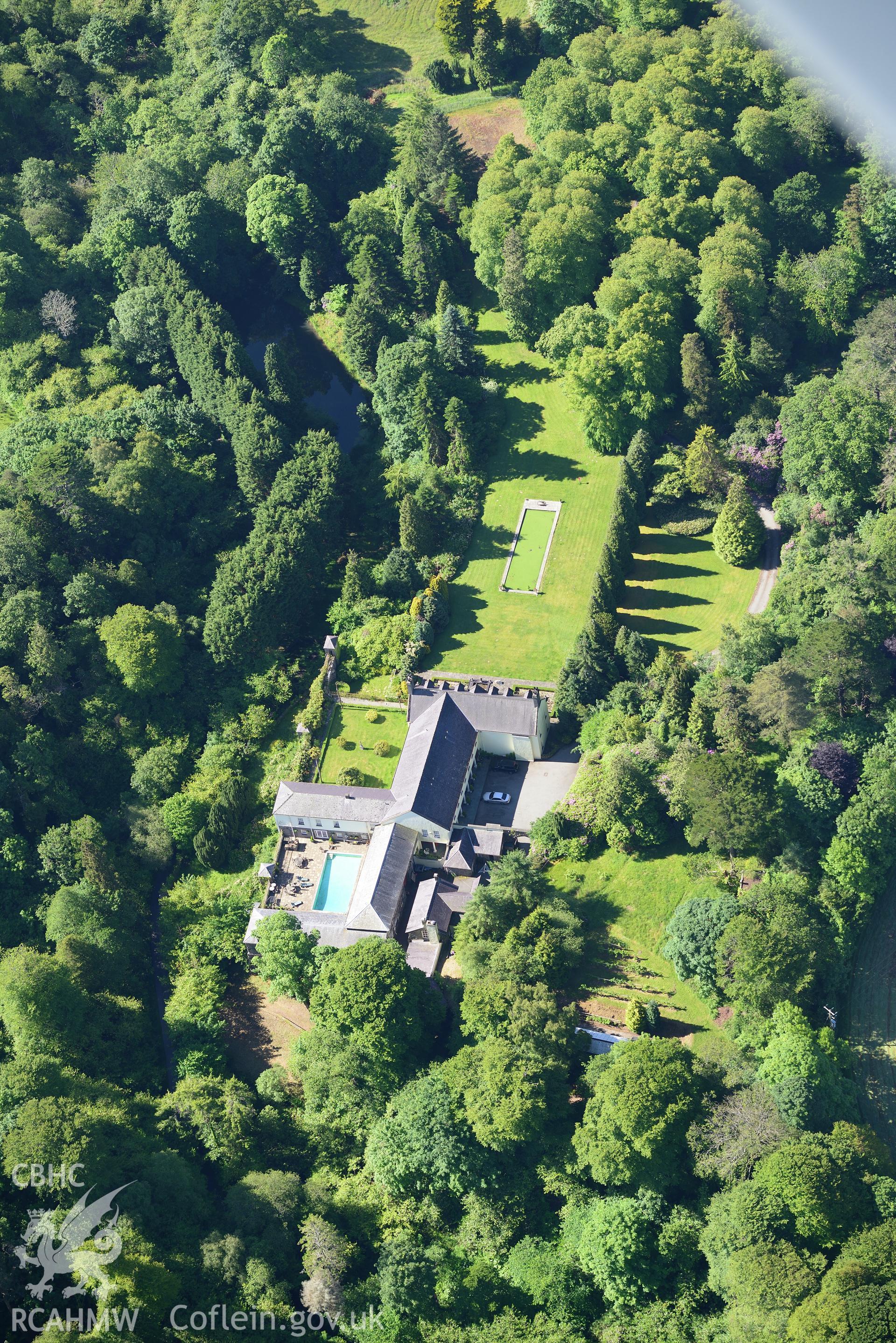 Plas Boduan surrounded by its park and gardens. Oblique aerial photograph taken during the Royal Commission's programme of archaeological aerial reconnaissance by Toby Driver on 23rd June 2015.
