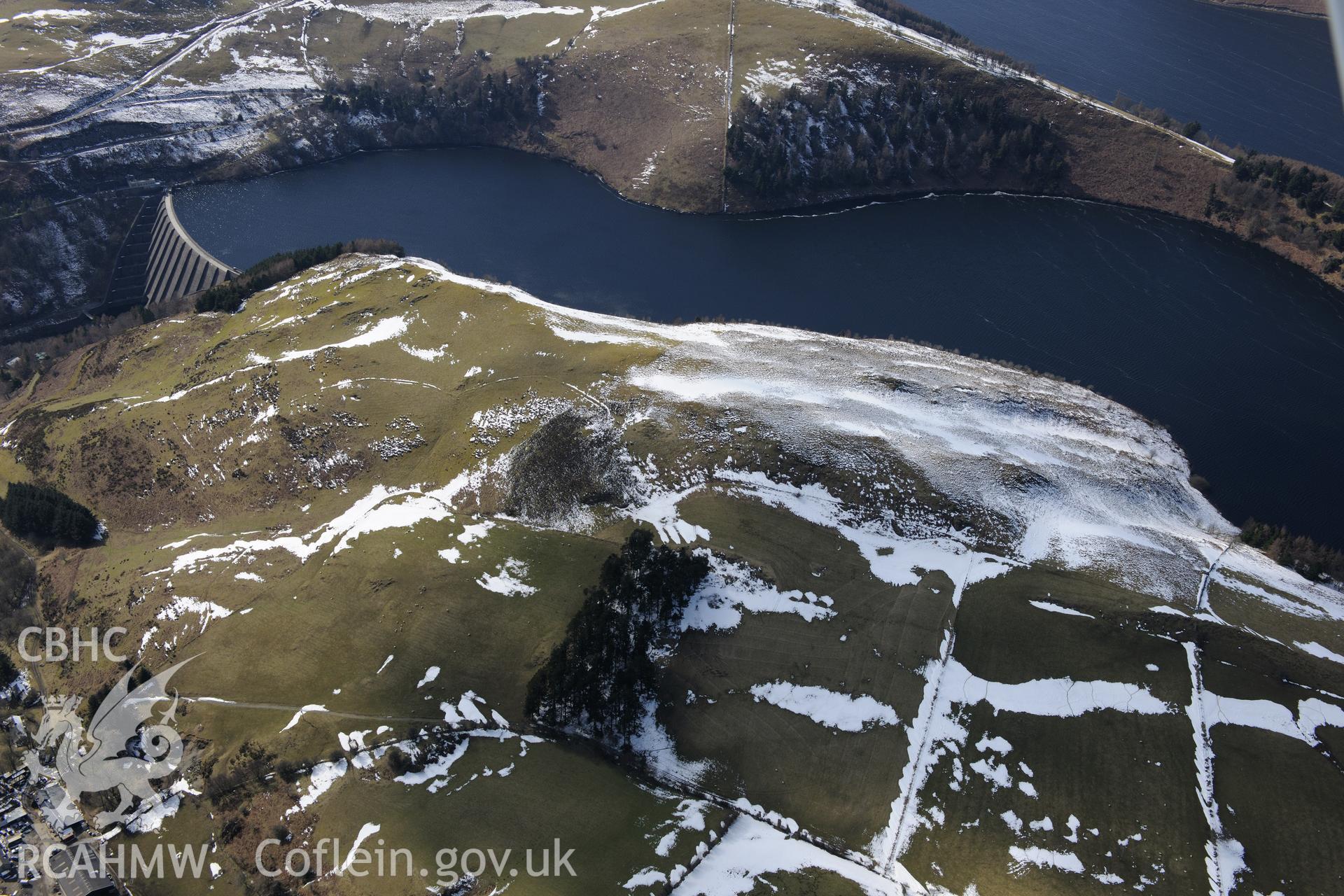 Llyn Clywedog reservoir and damn, with Bryn y Tail mining trail below, north west of Llanidloes. Oblique aerial photograph taken during the Royal Commission?s programme of archaeological aerial reconnaissance by Toby Driver on 2nd April 2015.