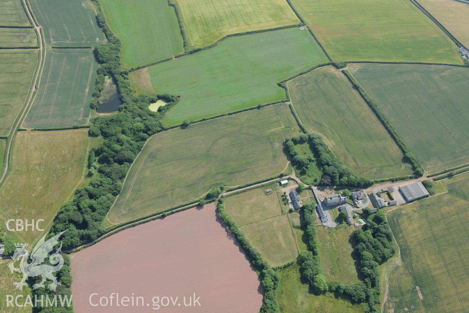 Butterhill farm with cropmarks east south south of the main farm buildings, near St Ishmaels. Oblique aerial photograph taken during the Royal Commission?s programme of archaeological aerial reconnaissance by Toby Driver on 16th July 2013.