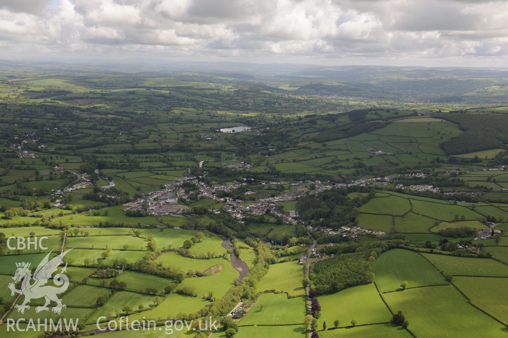 Landscape view looking north east at Llanybydder with Llyn Pencarreg in the distance. Oblique aerial photograph taken during the Royal Commission's programme of archaeological aerial reconnaissance by Toby Driver on 3rd June 2015.