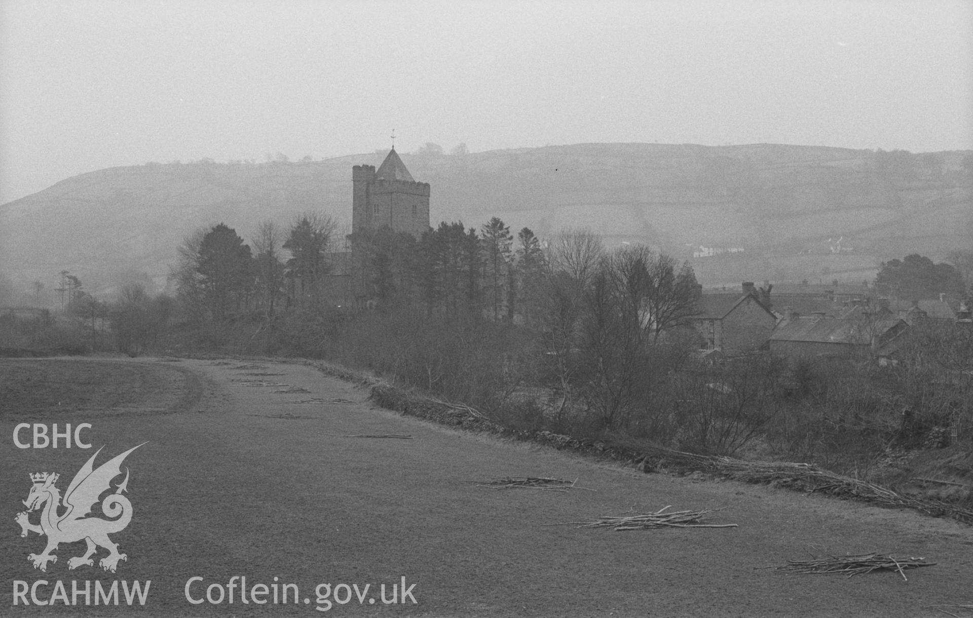 Digital copy of a black and white negative showing a prominent St David's Church in the village of Llanddewi Brefi. Photographed in April 1963 by Arthur O. Chater from across the Afon Brefi at Grid Reference SN 663 555, looking south south east.