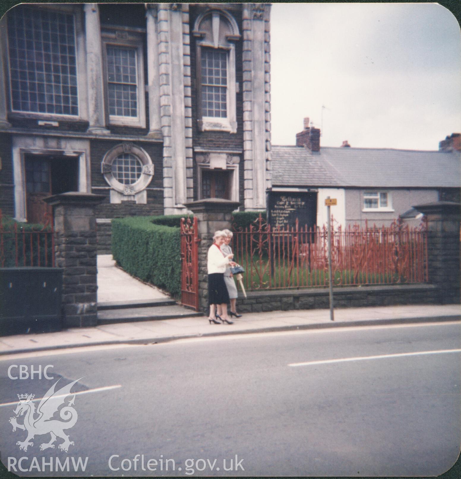 Colour photograph of soprano Cecilia Burnet and organist Ceinwen Bown outside the chapel at Whitsun, 1985. Donated to the RCAHMW by Cyril Philips as part of the Digital Dissent Project.