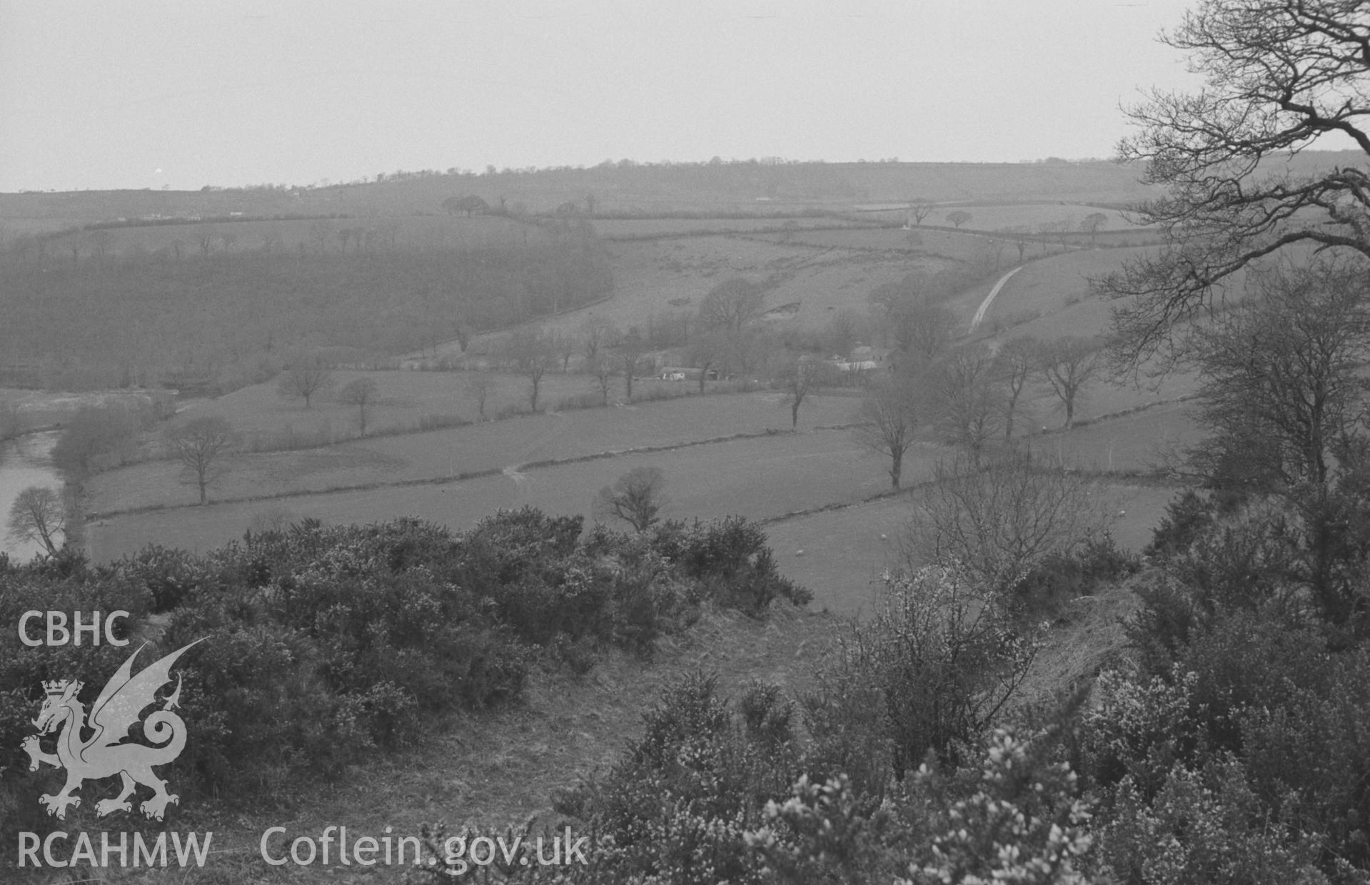 Digital copy of a black and white negative showing panoramic view looking north west over the 3-bank, 2-ditched Castell Pyr promontory fort earthworks. Glanrhydypysgod farm opposite. Photograph by Arthur O. Chater, April 1967. SN 470400. Photograph 3 of 4.