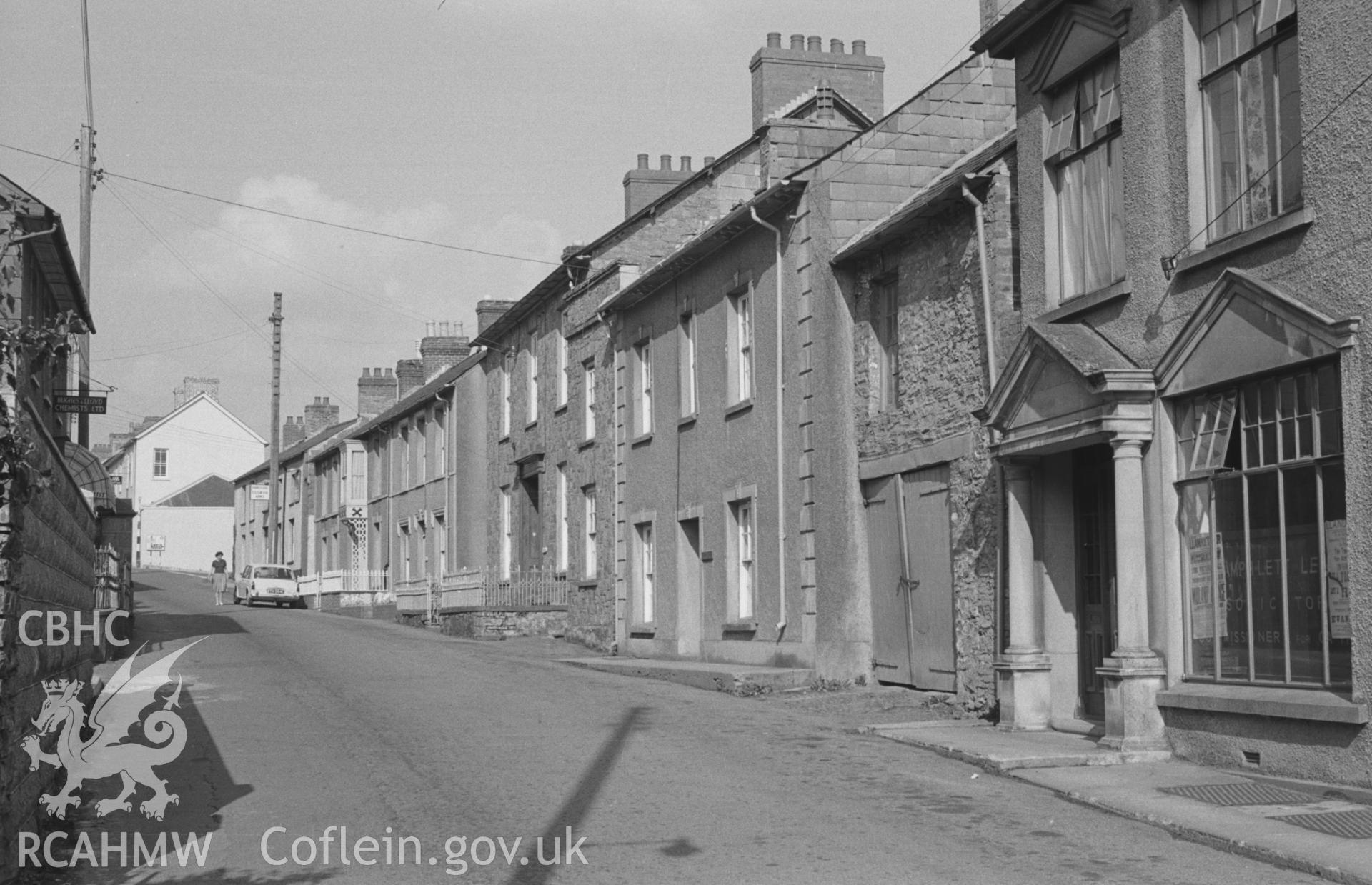 Digital copy of a black and white negative showing view of the main street to the Cilgwyn Arms Hotel in Llandysul. Photographed by Arthur O. Chater in August 1965, looking north north east.
