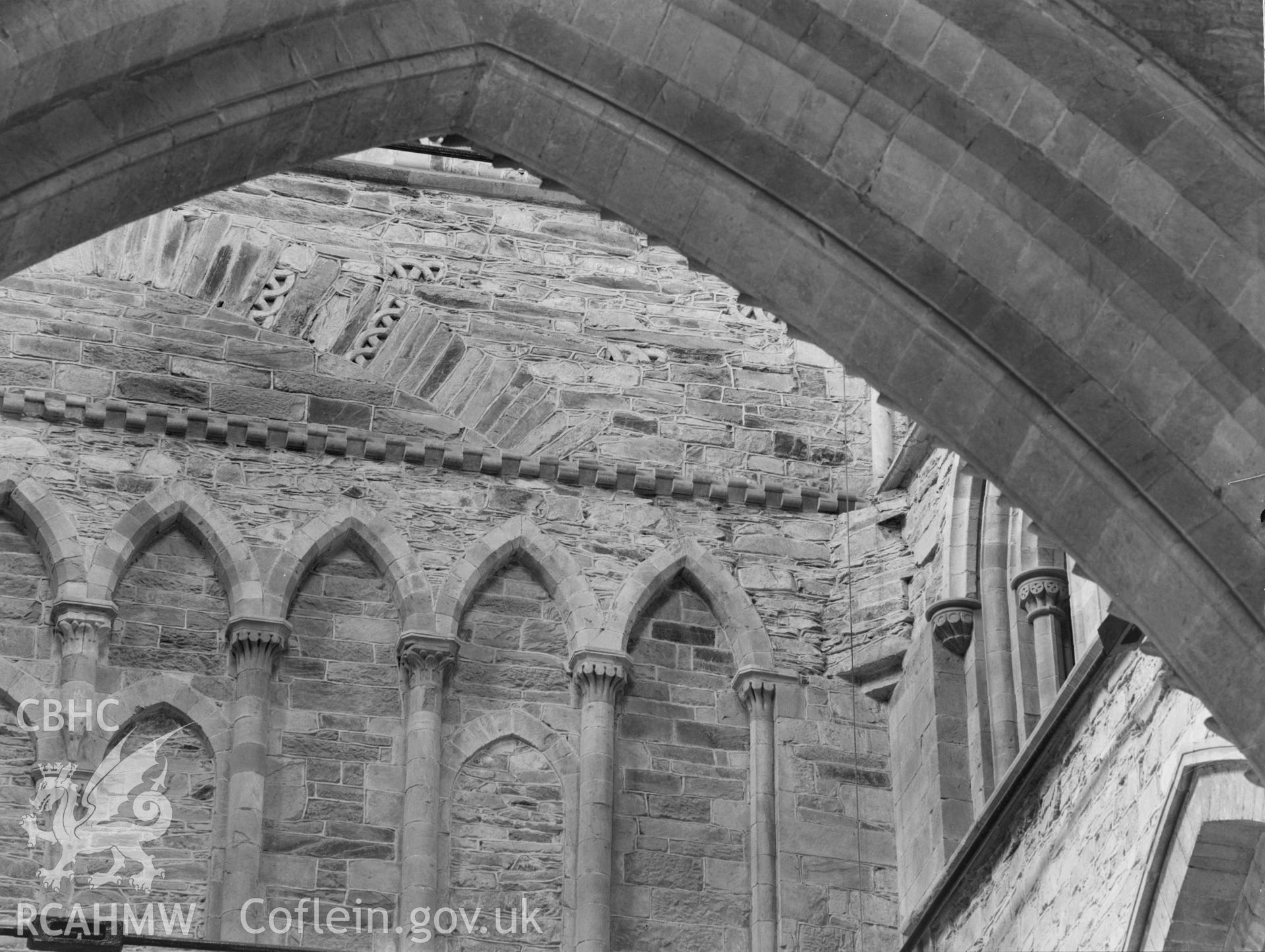 Digital copy of a black and white nitrate negative showing detailed view of arcaded wall through arch at St. David's Cathedral, taken by E.W. Lovegrove, July 1936.