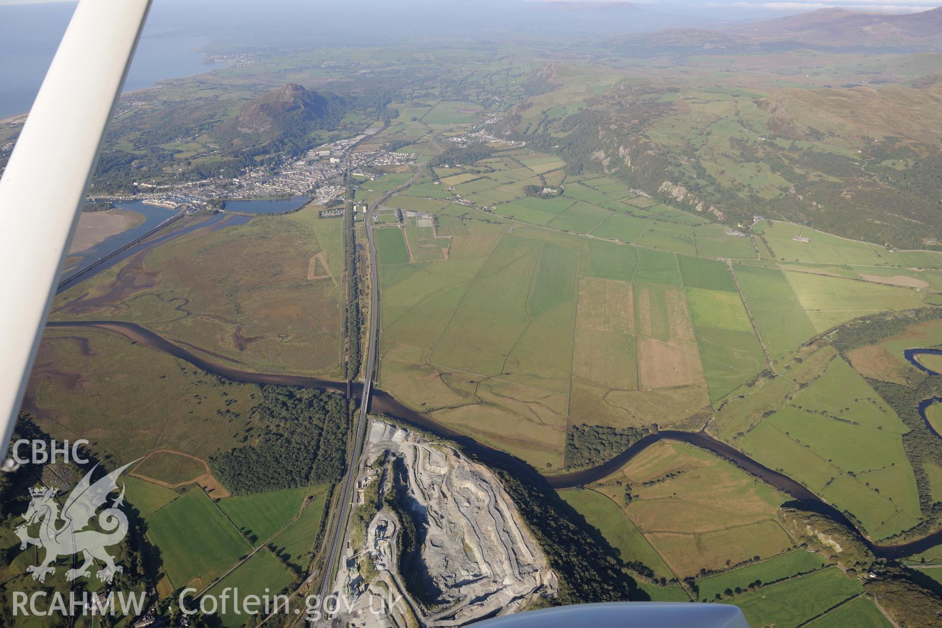 Ynys Gron granite quarry and the town of Porthmadog. Oblique aerial photograph taken during the Royal Commission's programme of archaeological aerial reconnaissance by Toby Driver on 2nd October 2015.