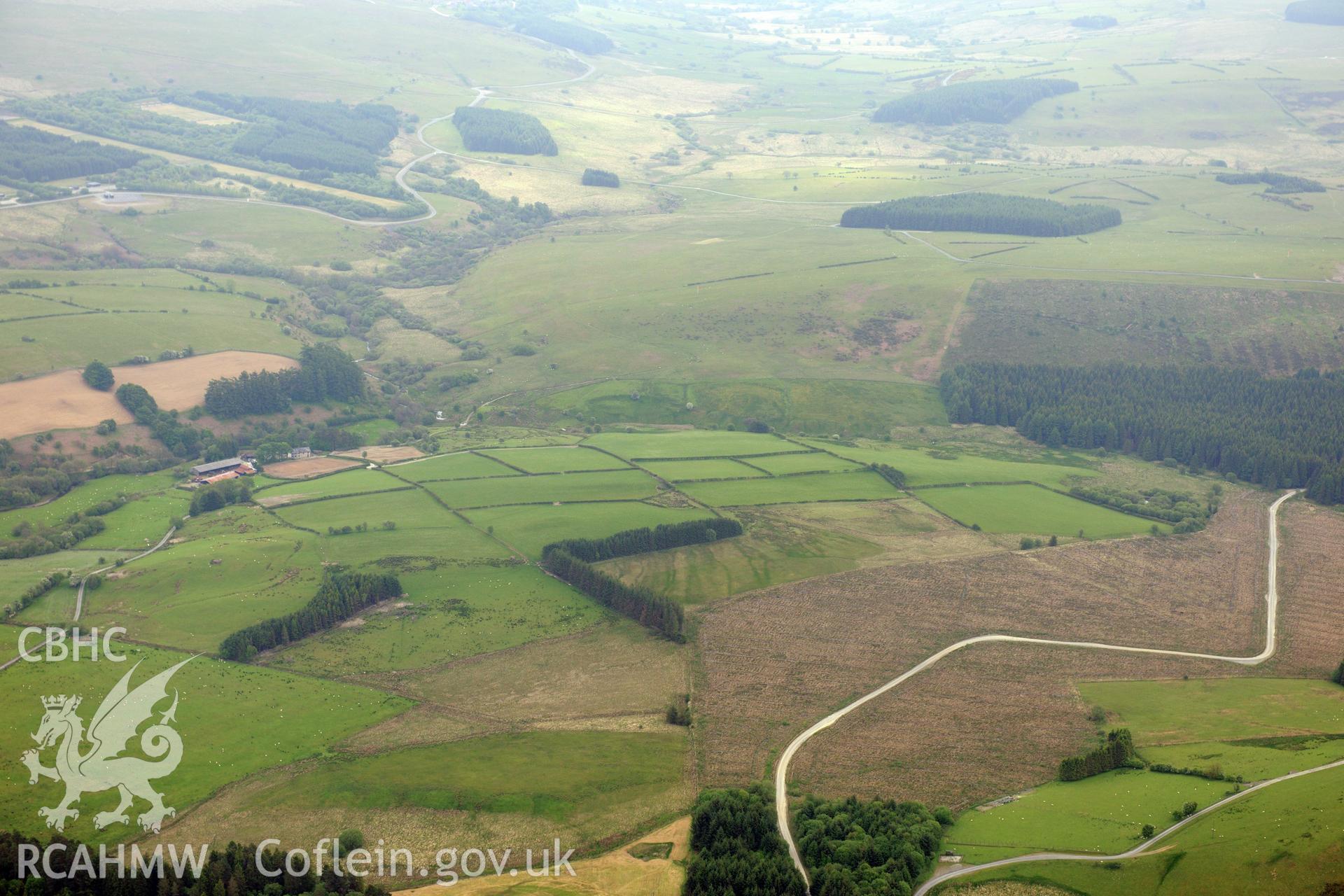 Possible Roman fort at Caerau and an enclosure at Gledrydd, now forested. Oblique aerial photograph taken during the Royal Commission's programme of archaeological aerial reconnaissance by Toby Driver on 11th June 2015.