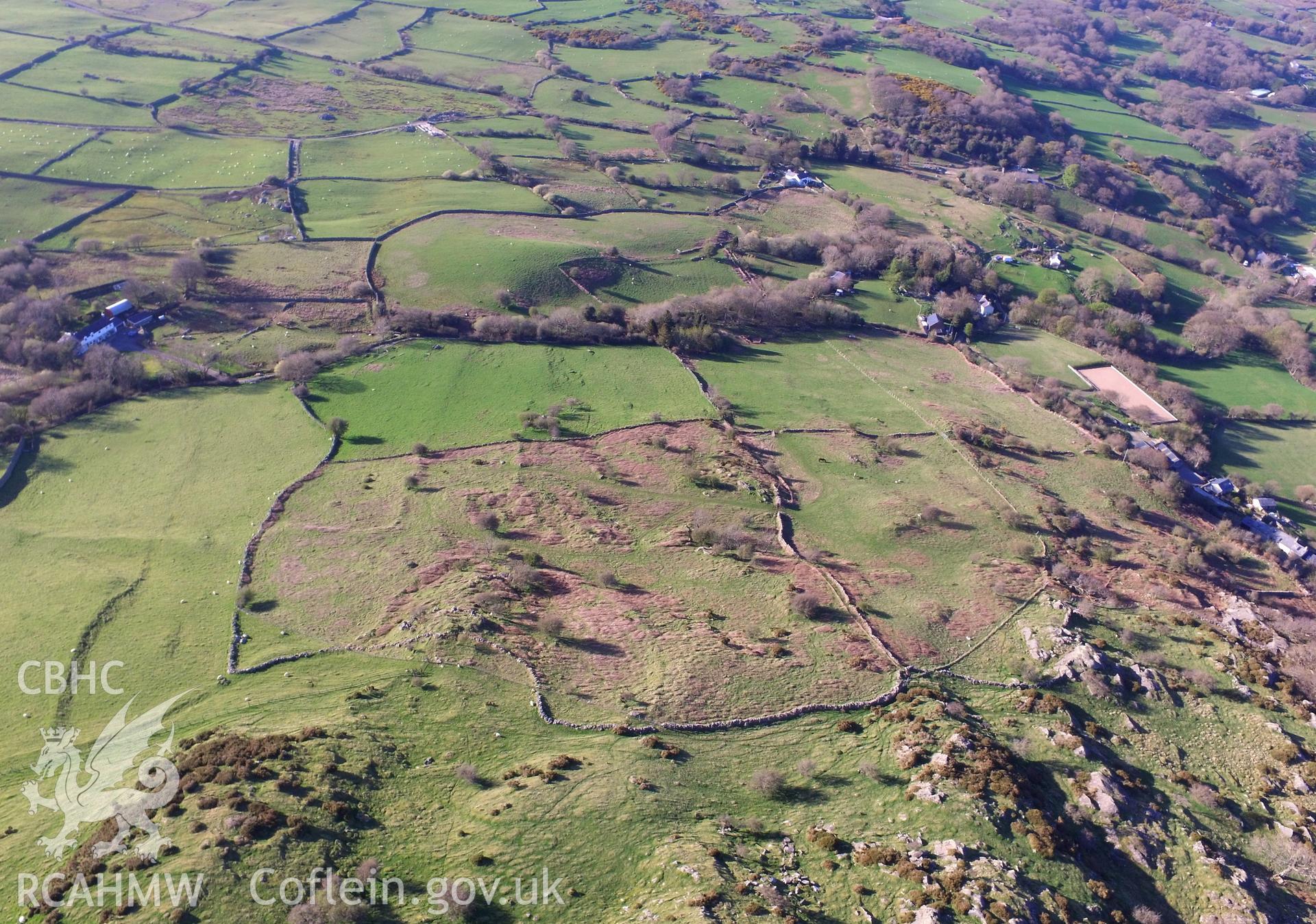 Colour photo showing aerial view of an enclosed hut group on the north slope of Cerrig-y-Dinas, taken by Paul R. Davis, 20th April 2018.