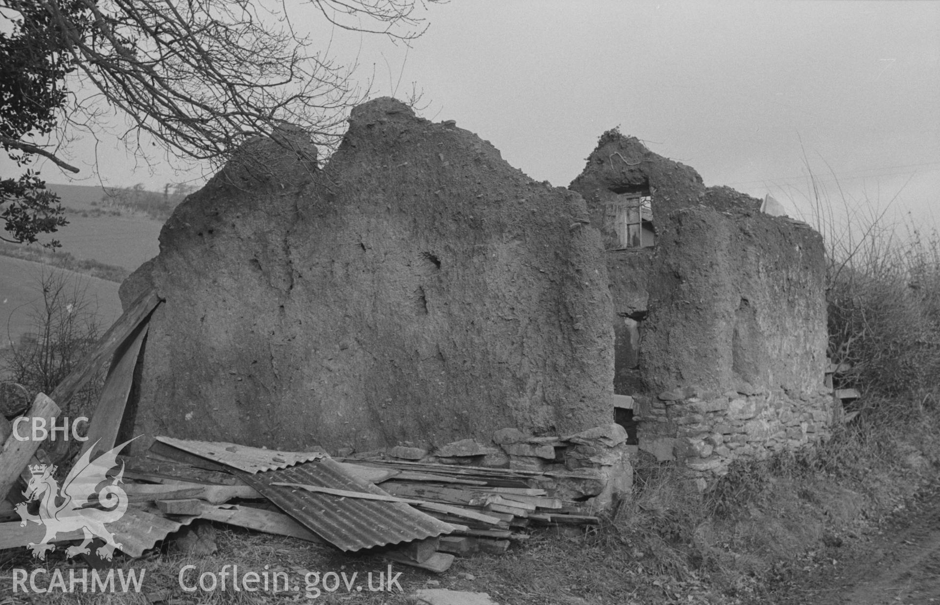 Digital copy of a black and white negative showing ruined mud cottage on the north side of Afon Llanfihangel 200m west of the Church. Photographed by Arthur O. Chater on 24th January 1968, looking north east from Grid Reference SN 664 760.