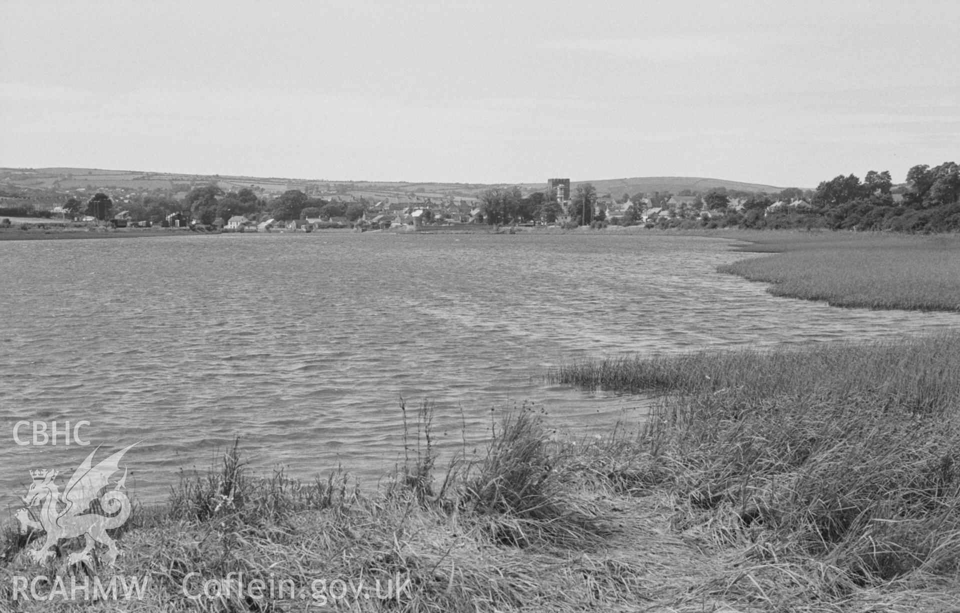 Black and White photograph showing Cardigan town and church from the north side of Afon Teifi at the mouth of Nant-Rhyd-y-Fuwch. Photographed by Arthur Chater in August 1962 from Grid Reference SN 187 458, looking west.