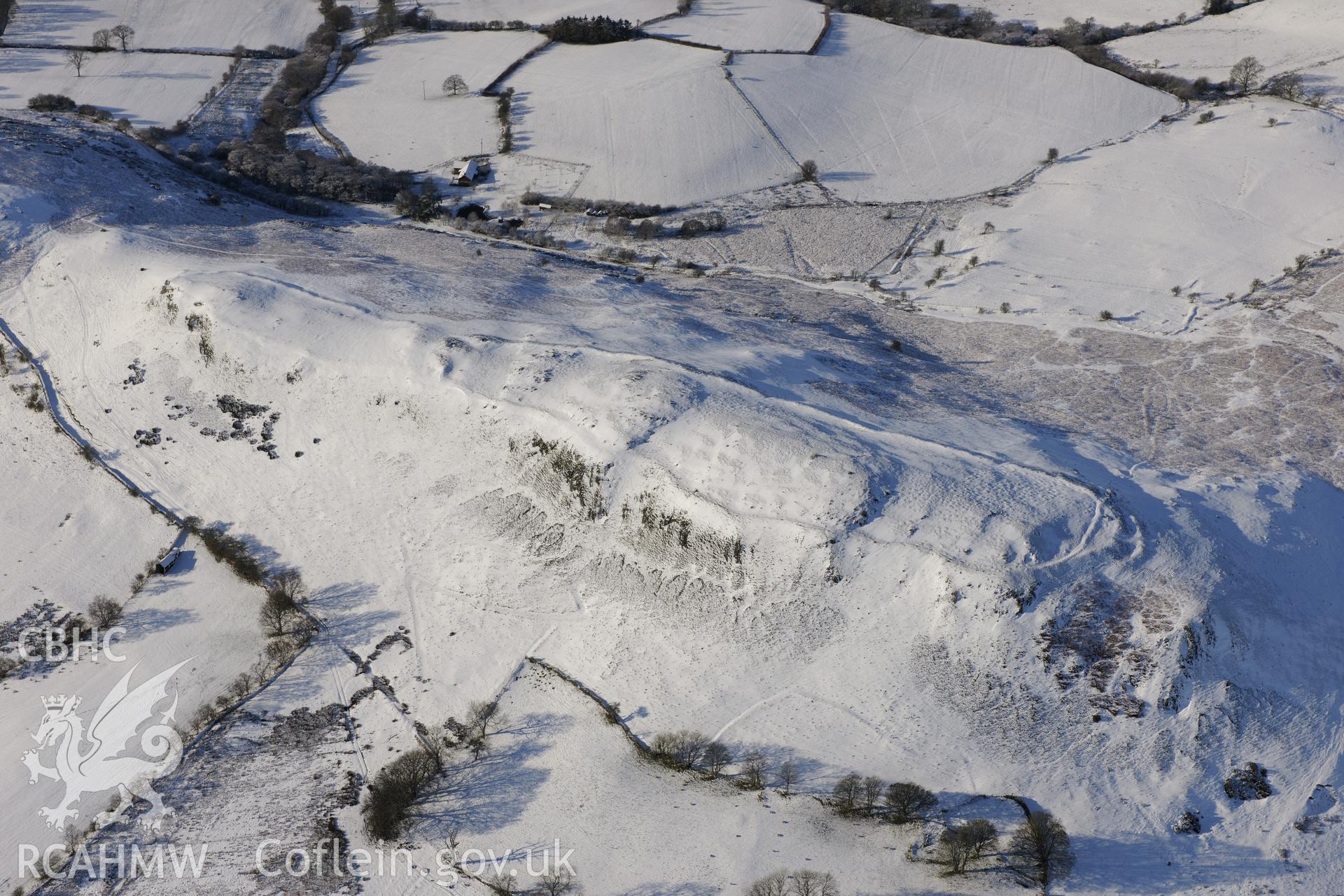 Castle Bank hillfort under snow, north east of Builth Wells. Oblique aerial photograph taken during the Royal Commission?s programme of archaeological aerial reconnaissance by Toby Driver on 15th January 2013.