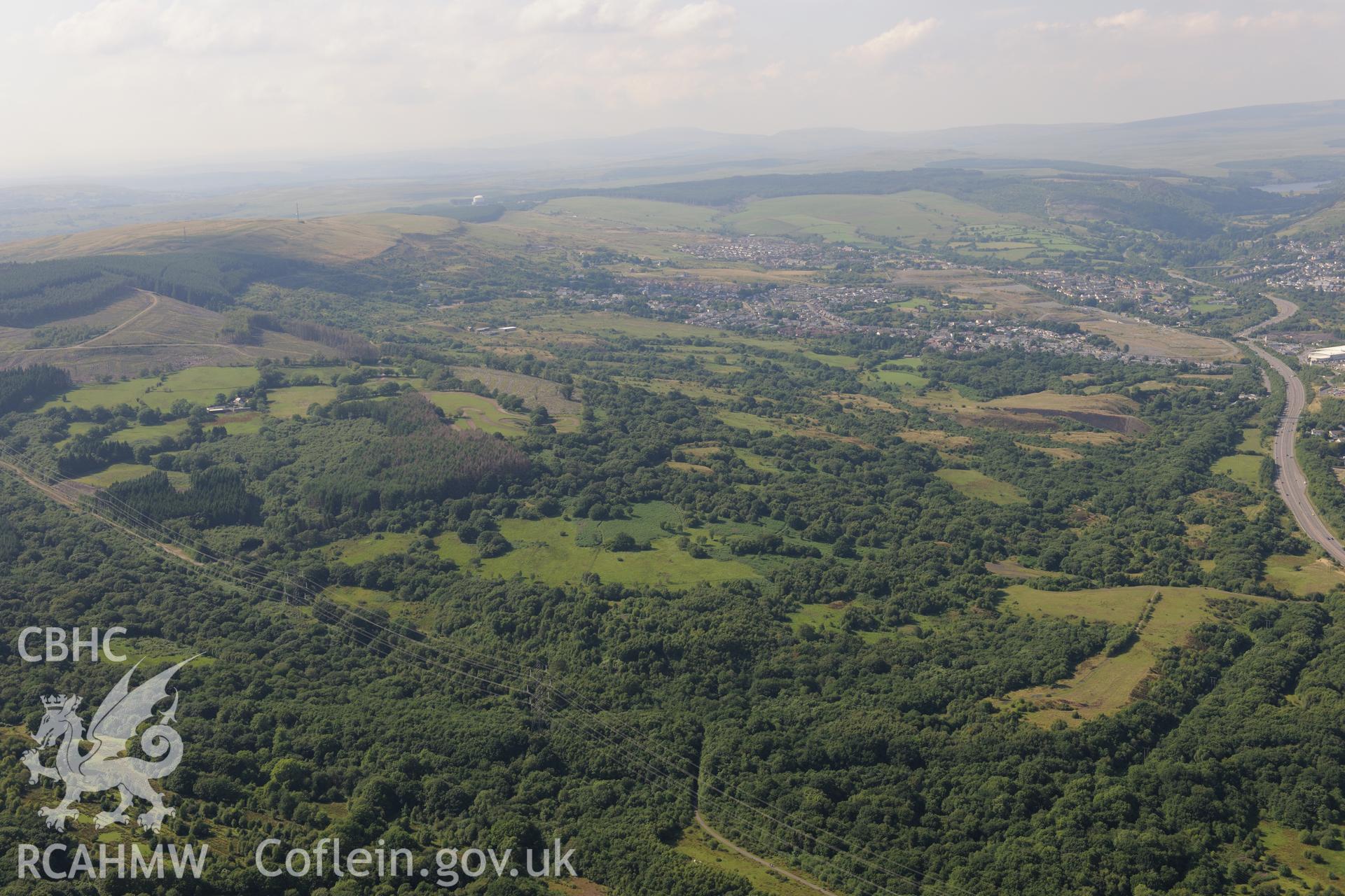 General view of the site of Cwm Pit colliery, with Merthyr Tydfil beyond. Oblique aerial photograph taken during the Royal Commission?s programme of archaeological aerial reconnaissance by Toby Driver on 1st August 2013.